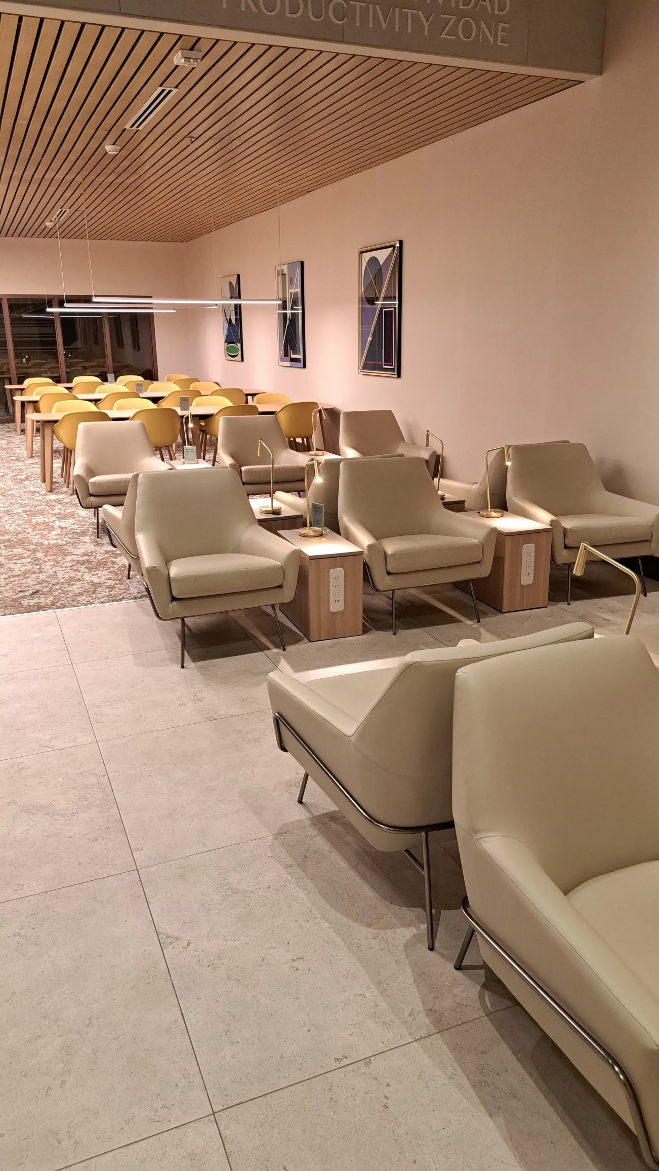 Lounge mit Sesseln und Tischen in neutralen Farben