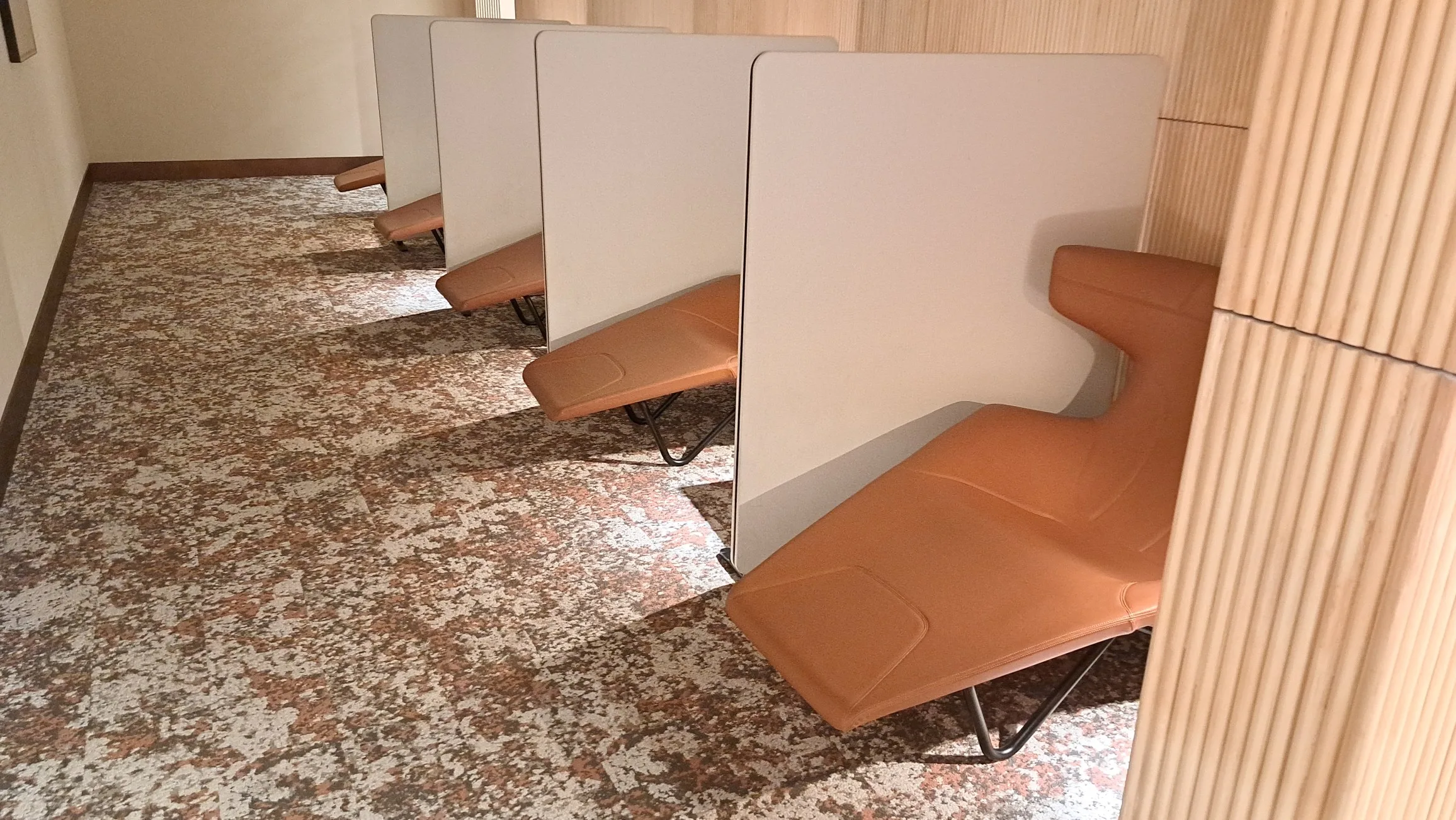 Reihen von Sitzplätzen mit getrennten Wänden im Flughafenlounge