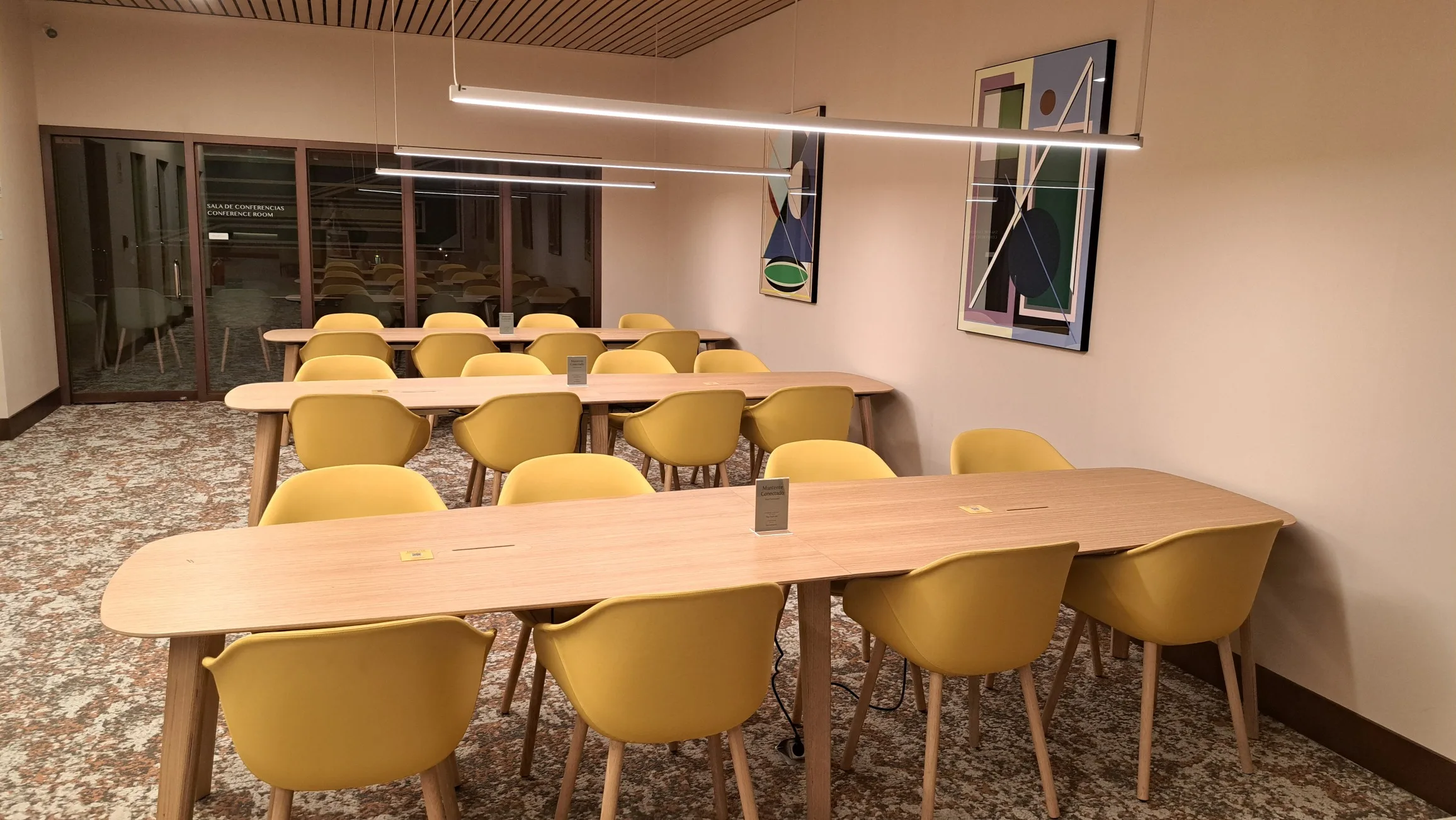 Konferenzraum mit gelben Stühlen und Holztischen