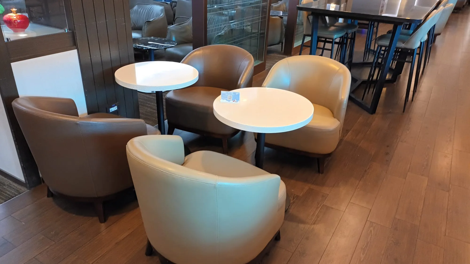 Lounge mit Sesseln und runden Tischen