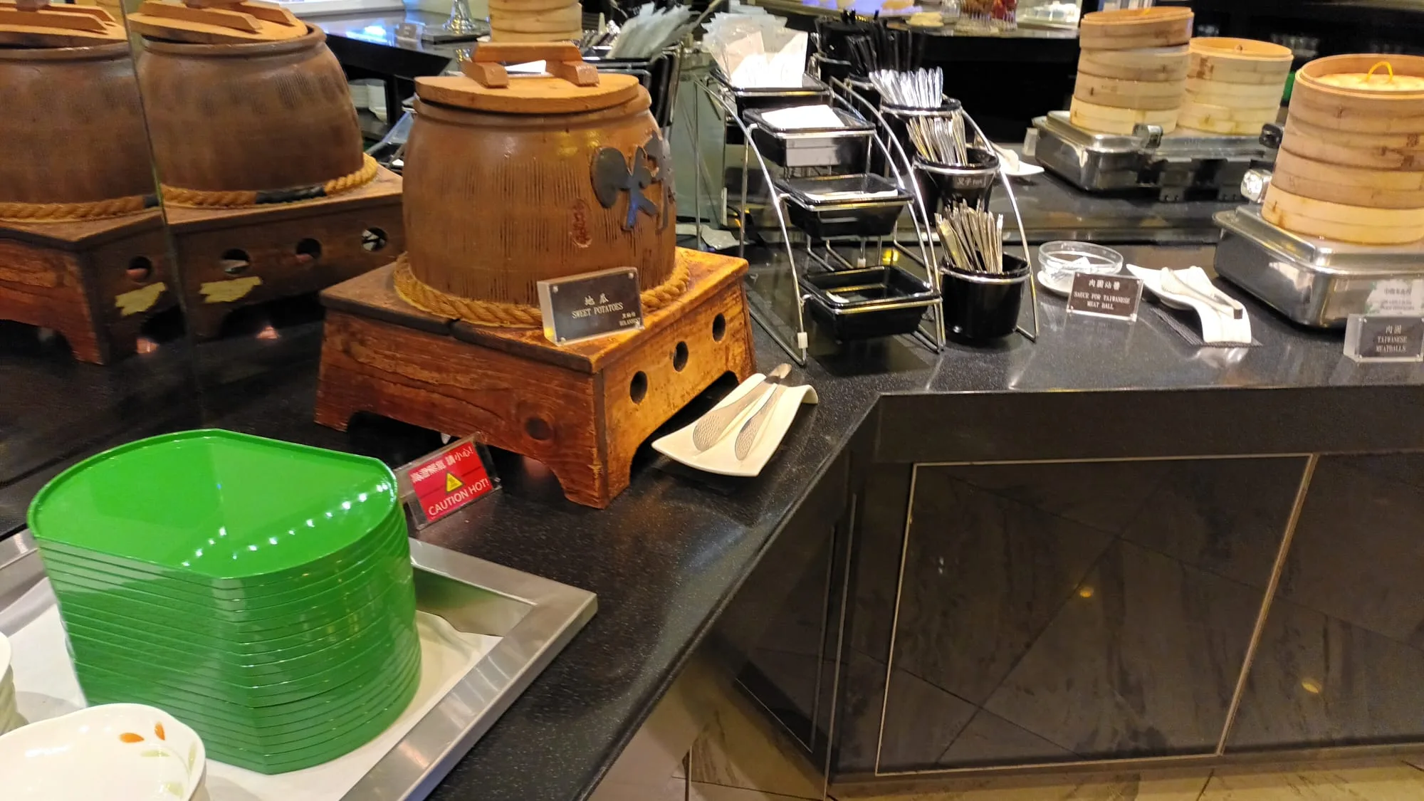Buffet mit traditionellen chinesischen Geräten und grünen Platten