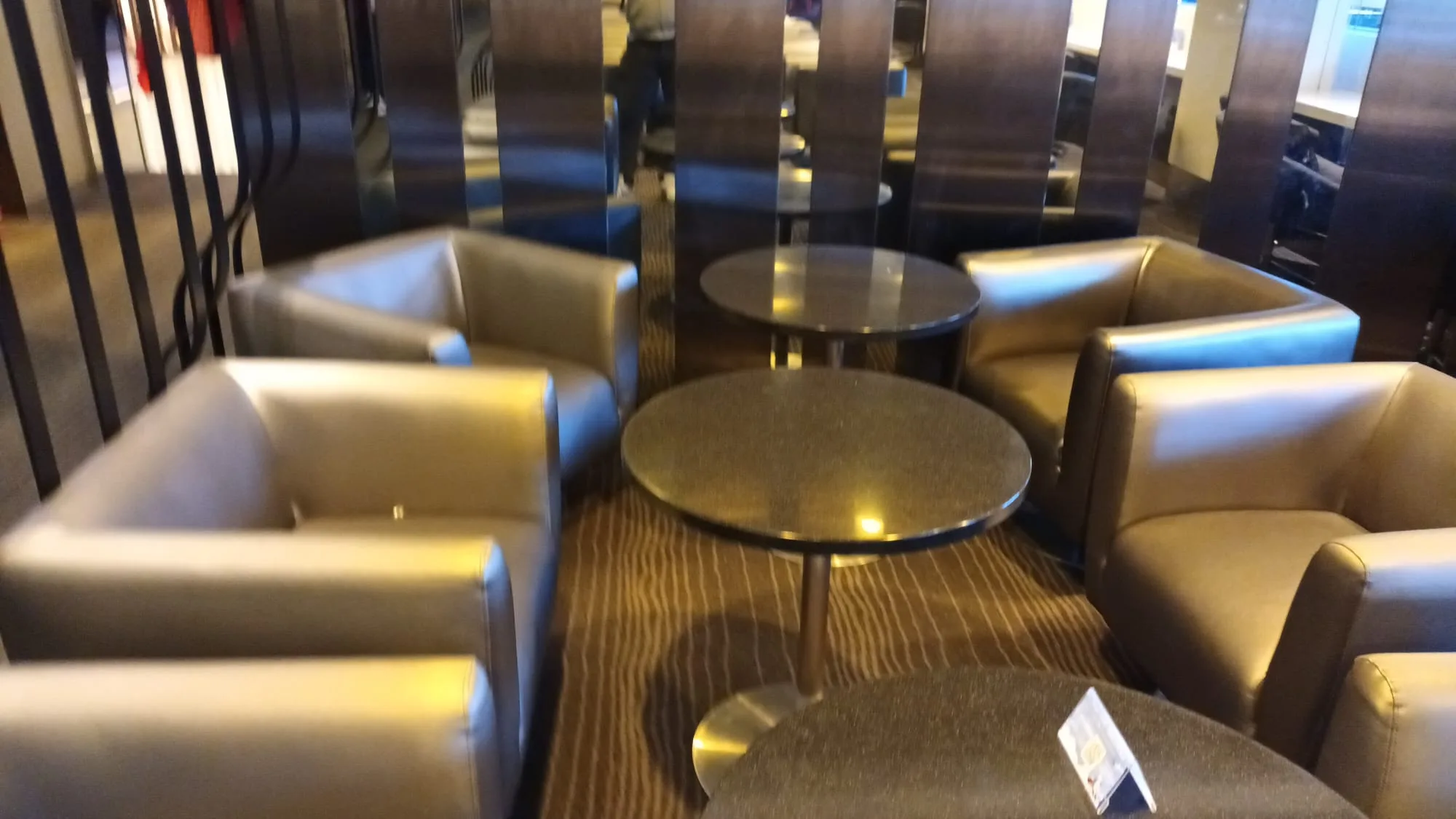 Lounge mit Sesseln und runden Tischen
