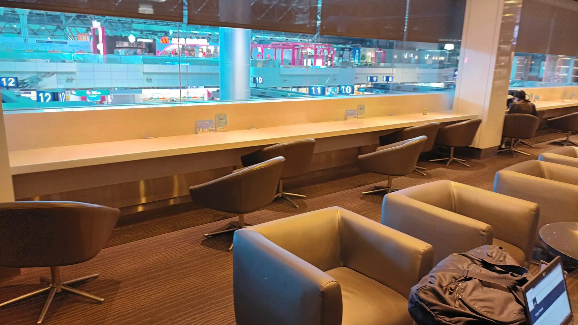 Infinity Lounge mit Sesseln und Tischen im Flughafen