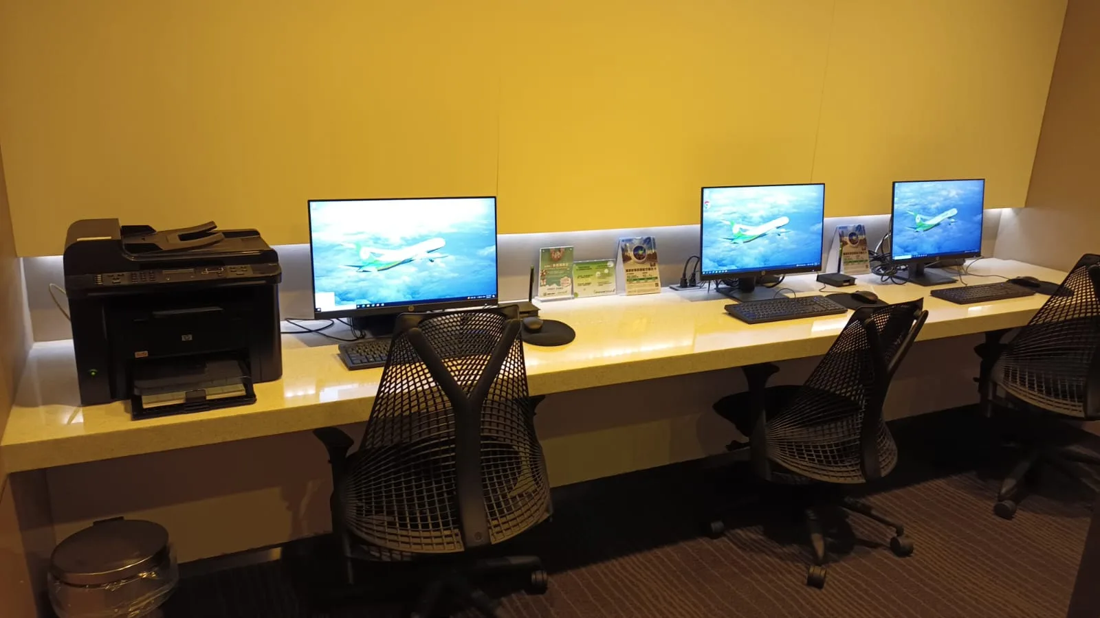 Arbeitsplatz mit Computern und Drucker in einem Flughafenlounge