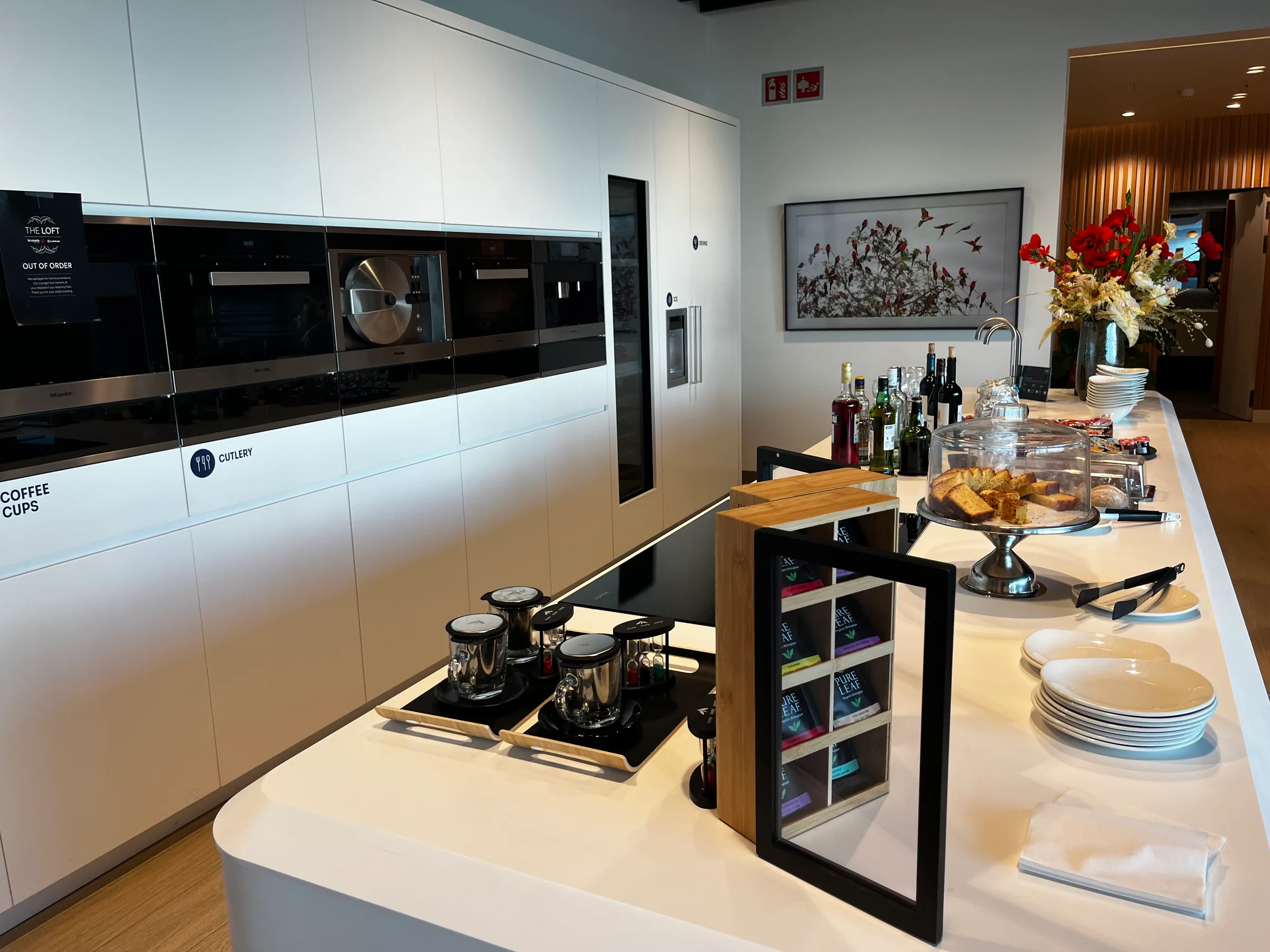 Modernes Lounge-Kücheninterieur mit Kaffeezubereitung und Snacks