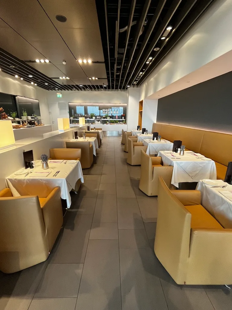 Lounge mit gelben Polstern und weißen Tischdecken