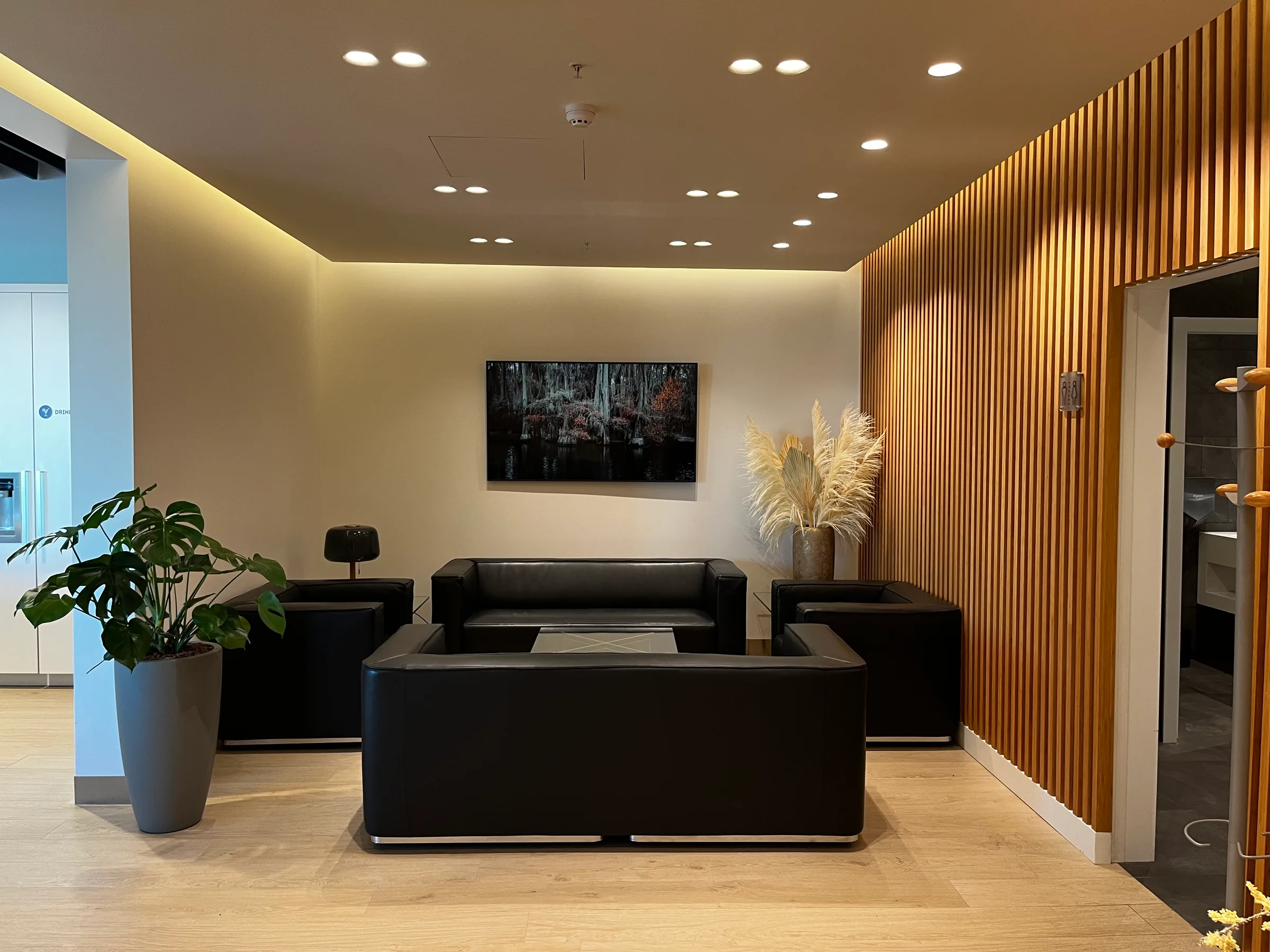 Lounge mit schwarzen Sofas und Pflanzen