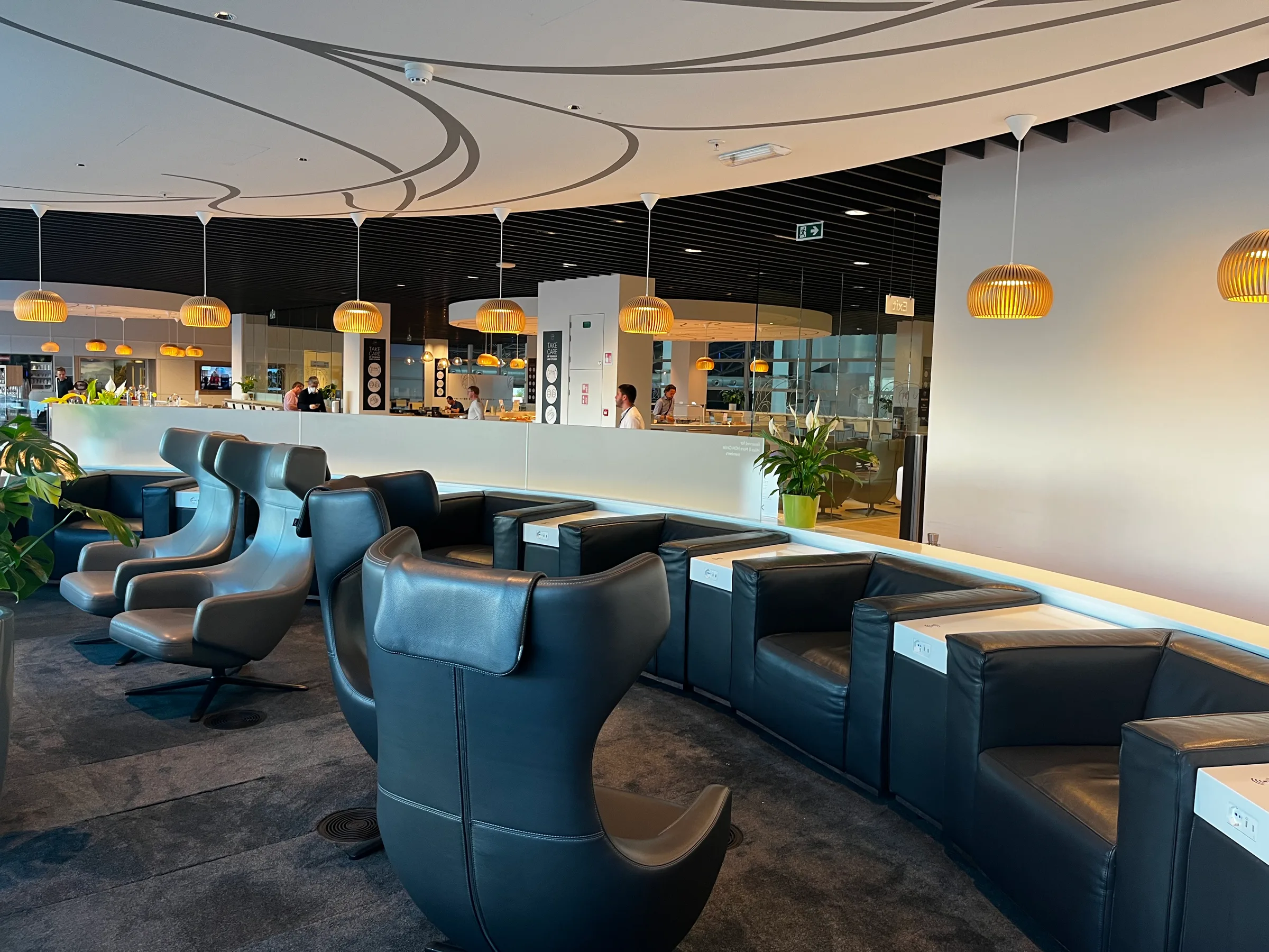 Lounge mit blauen Sesseln und Bar im Hintergrund