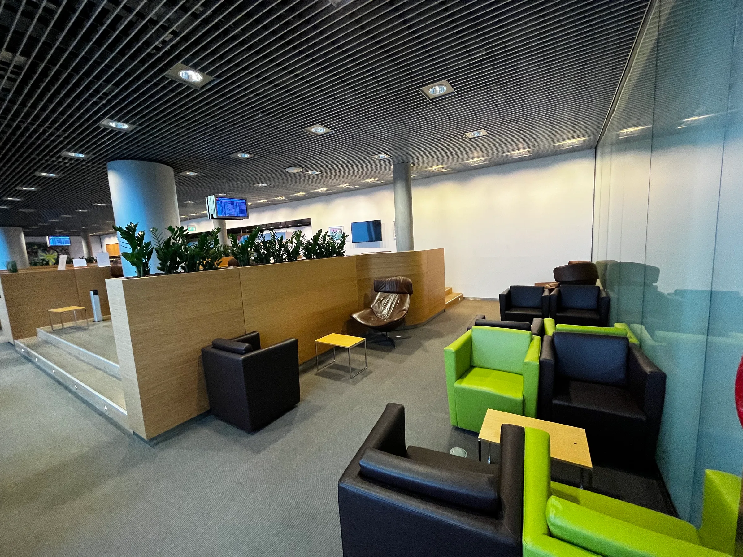 Lounge mit Sesseln und Pflanzen im Flughafen