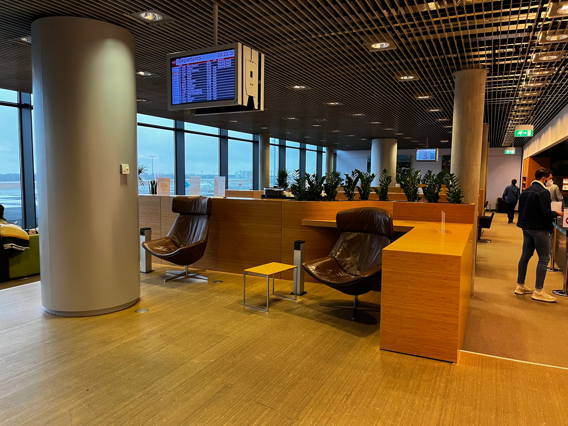 Lounge mit Sesseln und Pflanzen im Flughafen