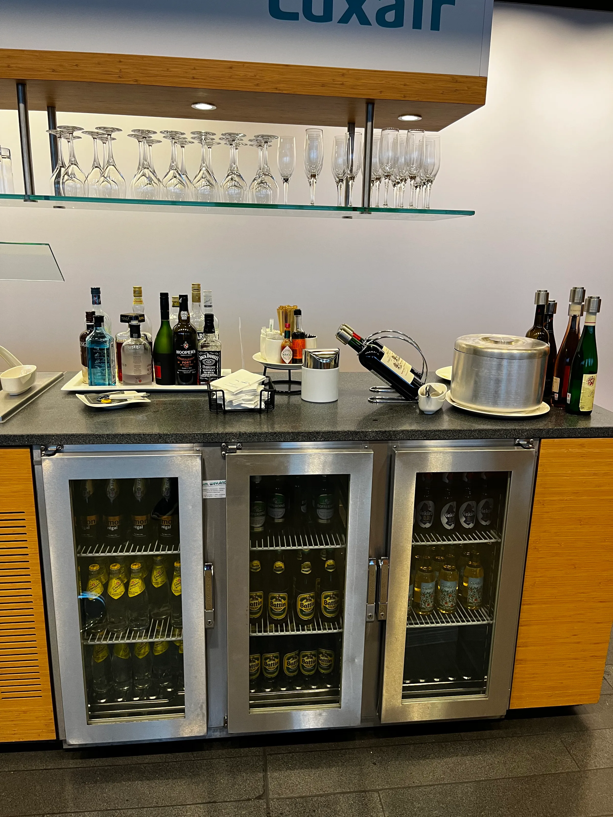 Bar mit Getränken und Kühlschränken im Flughafensalon