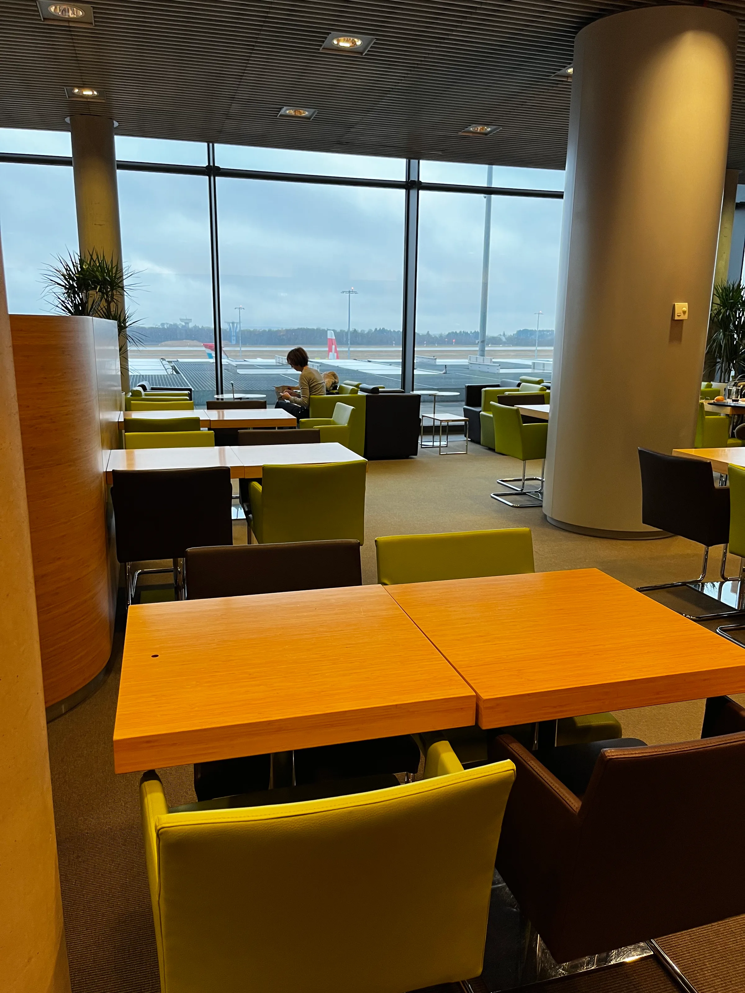Lounge mit Sitzgelegenheiten und Blick auf Flughafen