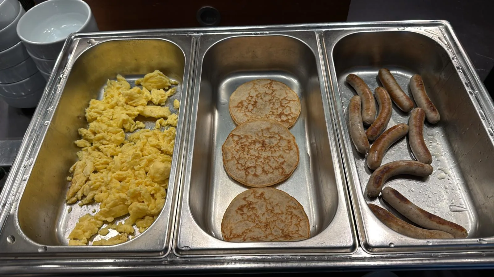 Eier, Pfannkuchen und Würstchen auf Buffet-Tellern