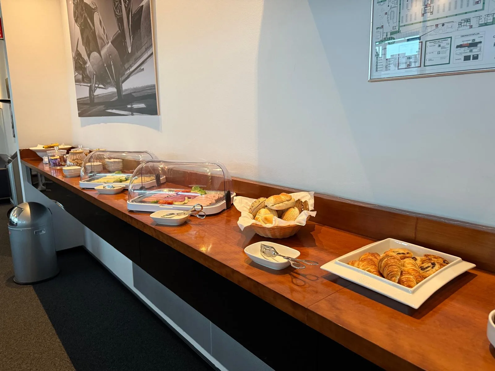 Frühstückstablett mit Käse, Schinken und Croissants auf Holztisch