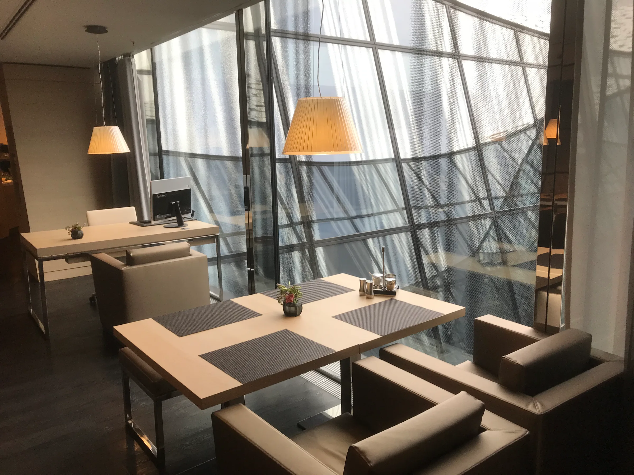Hotelzimmer mit Tisch und Stühlen vor großem Fenster