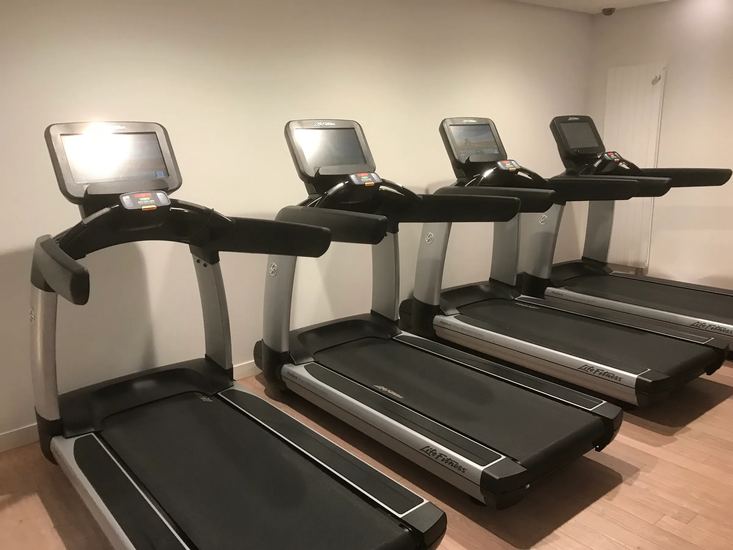 Vier Laufbänder in einem Fitnessraum