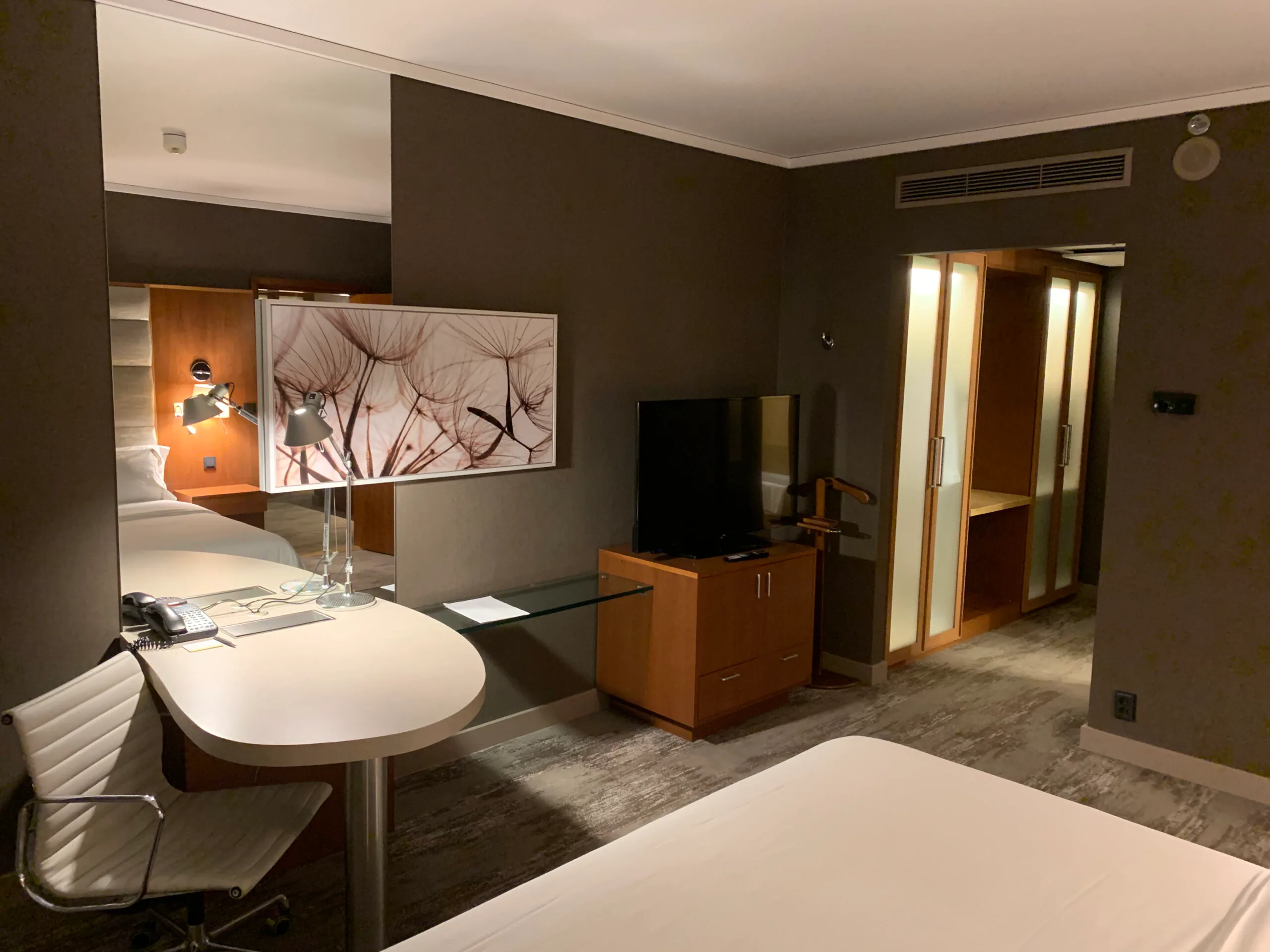 Hotelzimmer mit Doppelbett und Schreibtisch in Grautönen