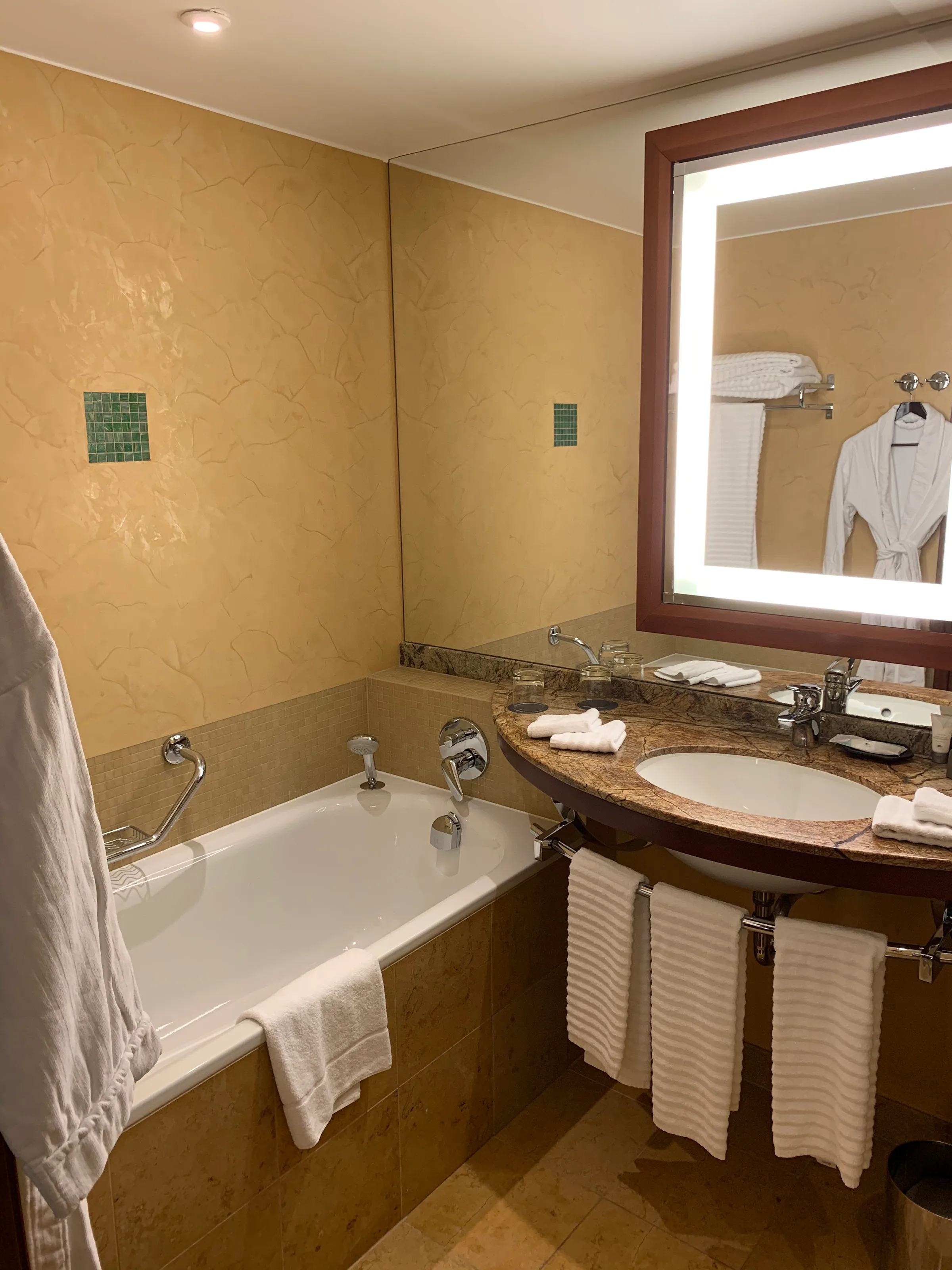 Hotelbad mit Badewanne, Waschbecken und Spiegel