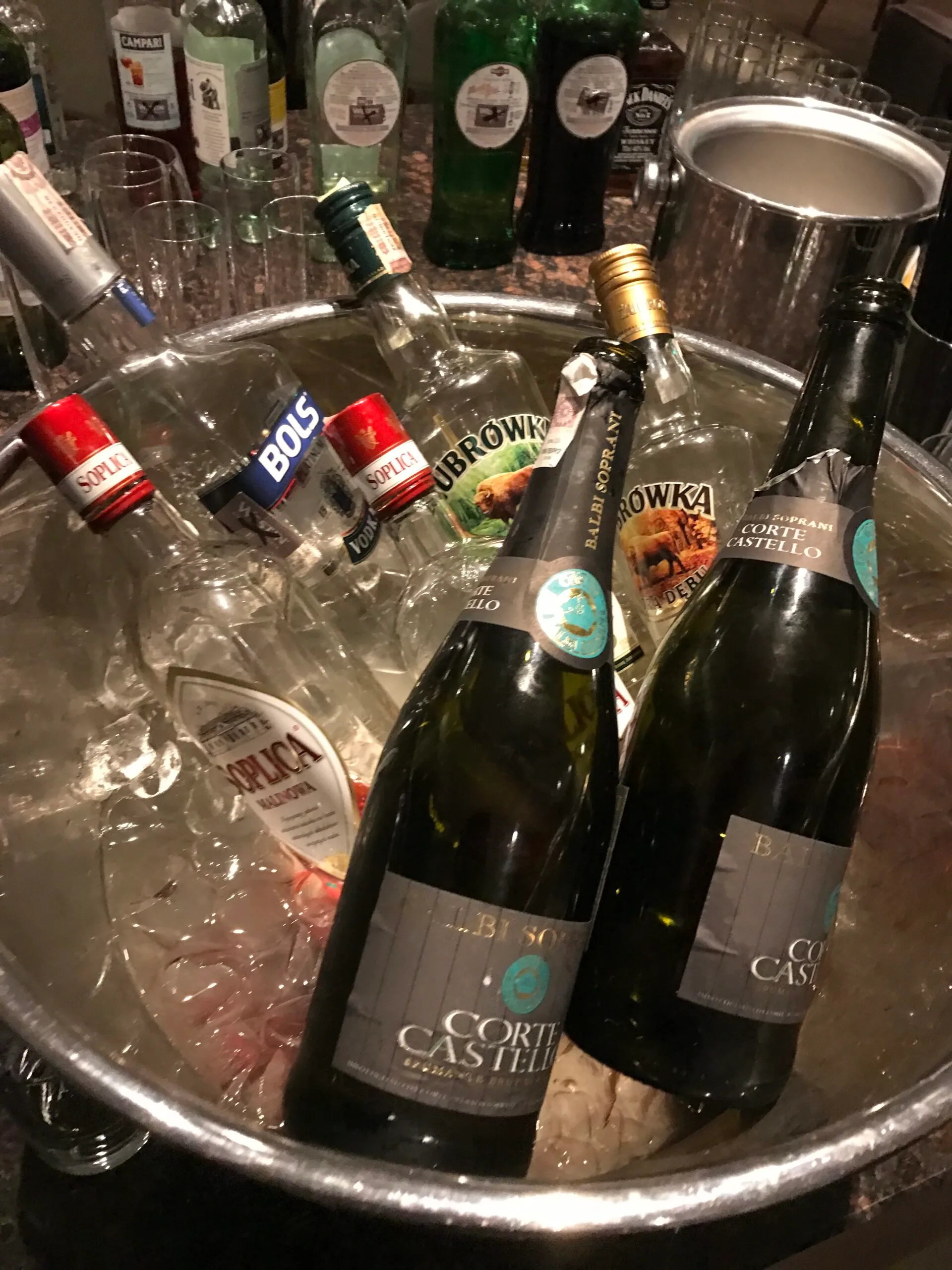 Eisgefüllter Eimer mit Flaschen von Corti Castello und anderen Spirituosen