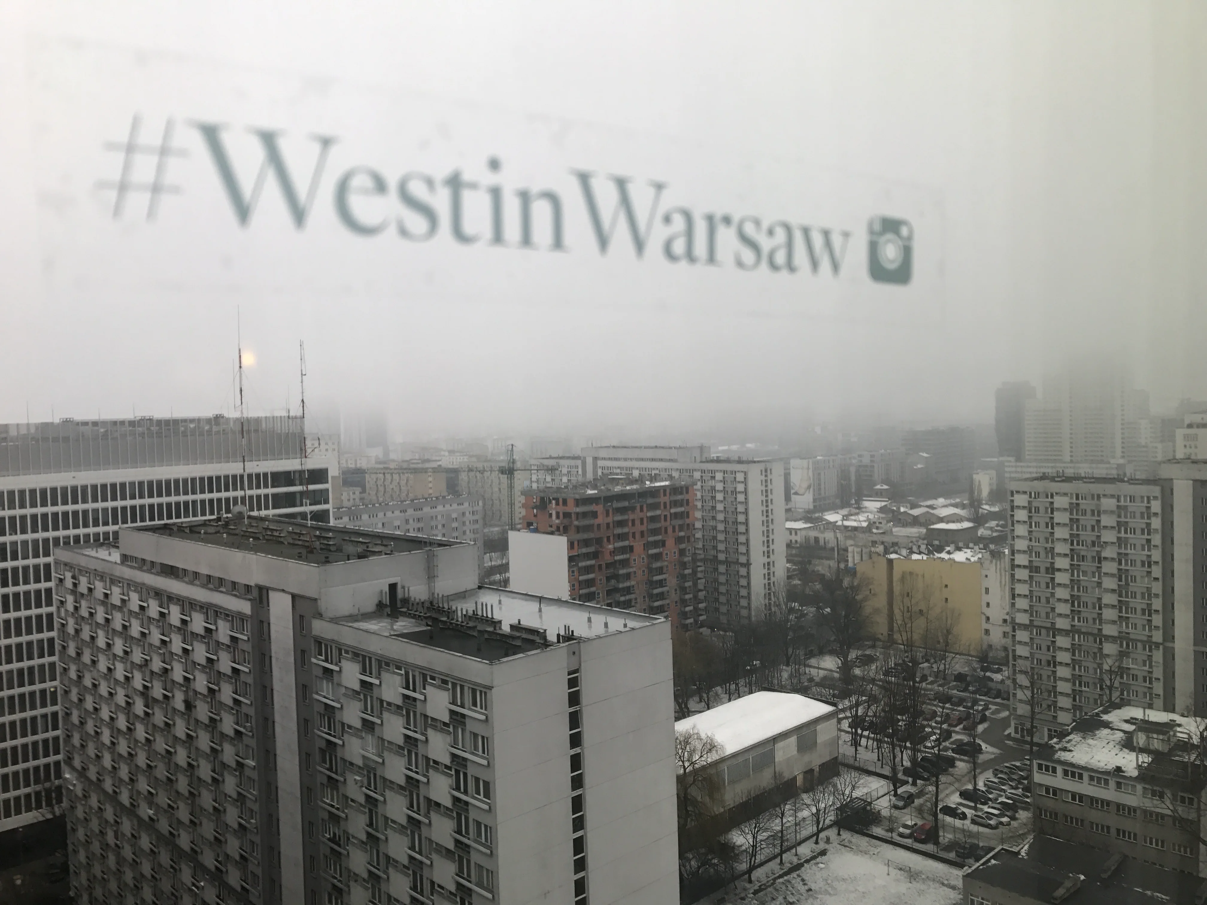 Stadtansicht aus dem Fenster eines Hotels mit Wolken und Hochhäusern