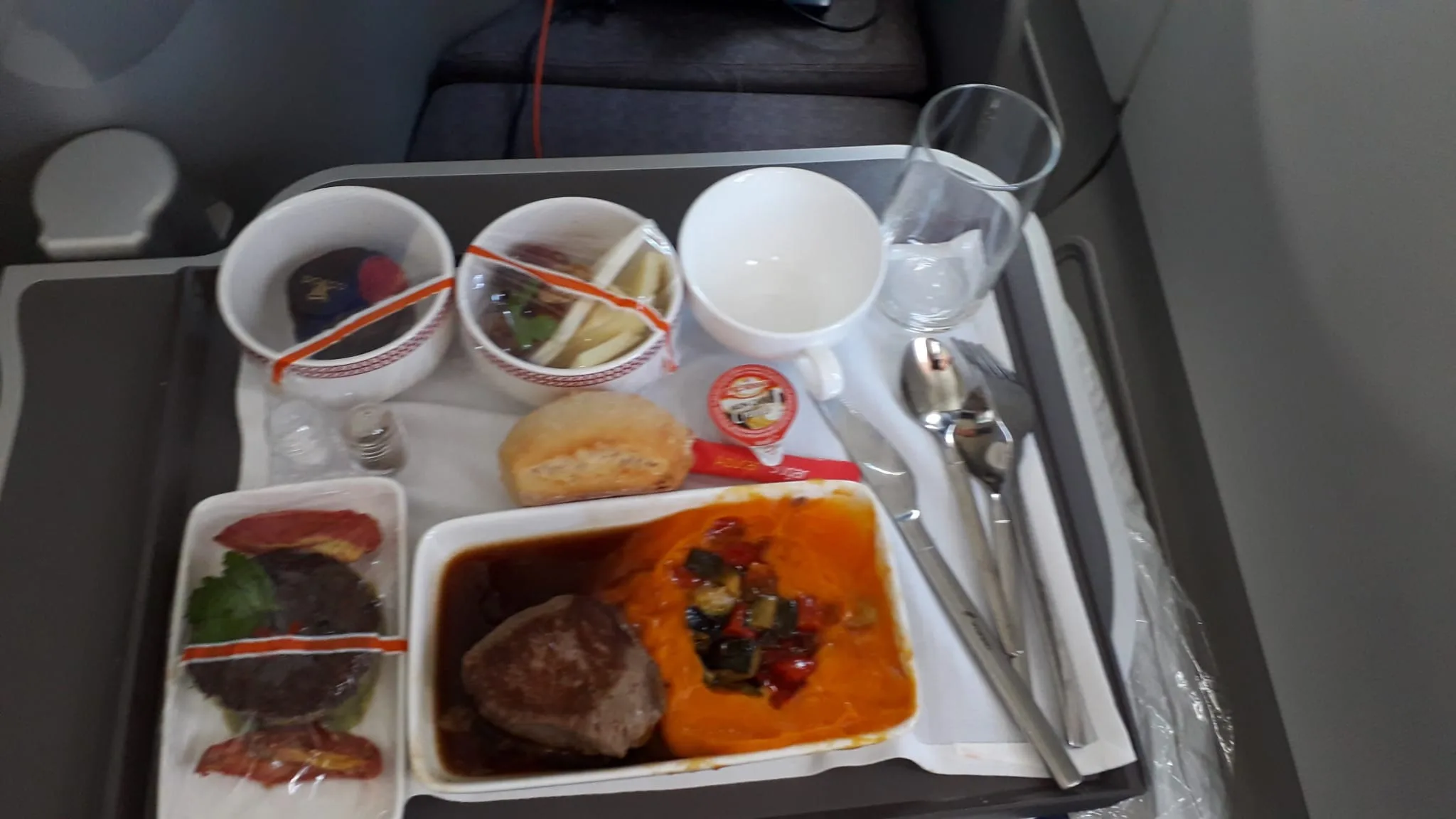 Gedeckter Flugzeugtisch mit Essen und Getränken