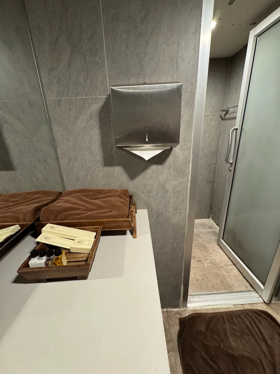 Wand mit grauen Fliesen und Handtuchhalter im Flughafenlounge