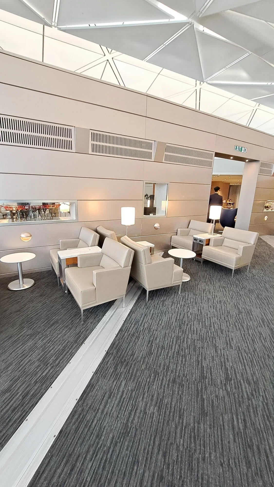 Lounge mit Sesseln und Tischen in neutralen Farben