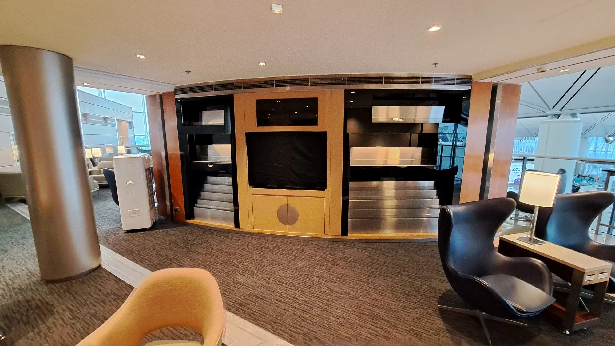 Lounge mit Sitzmöbeln und Regalwand