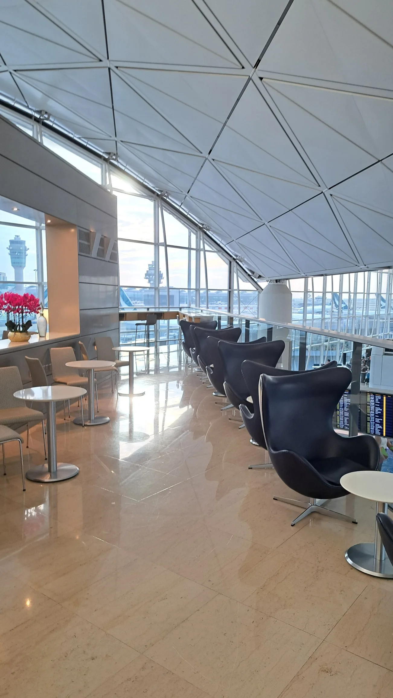 Lounge mit schwarzen Stühlen und Tischen im Flughafen