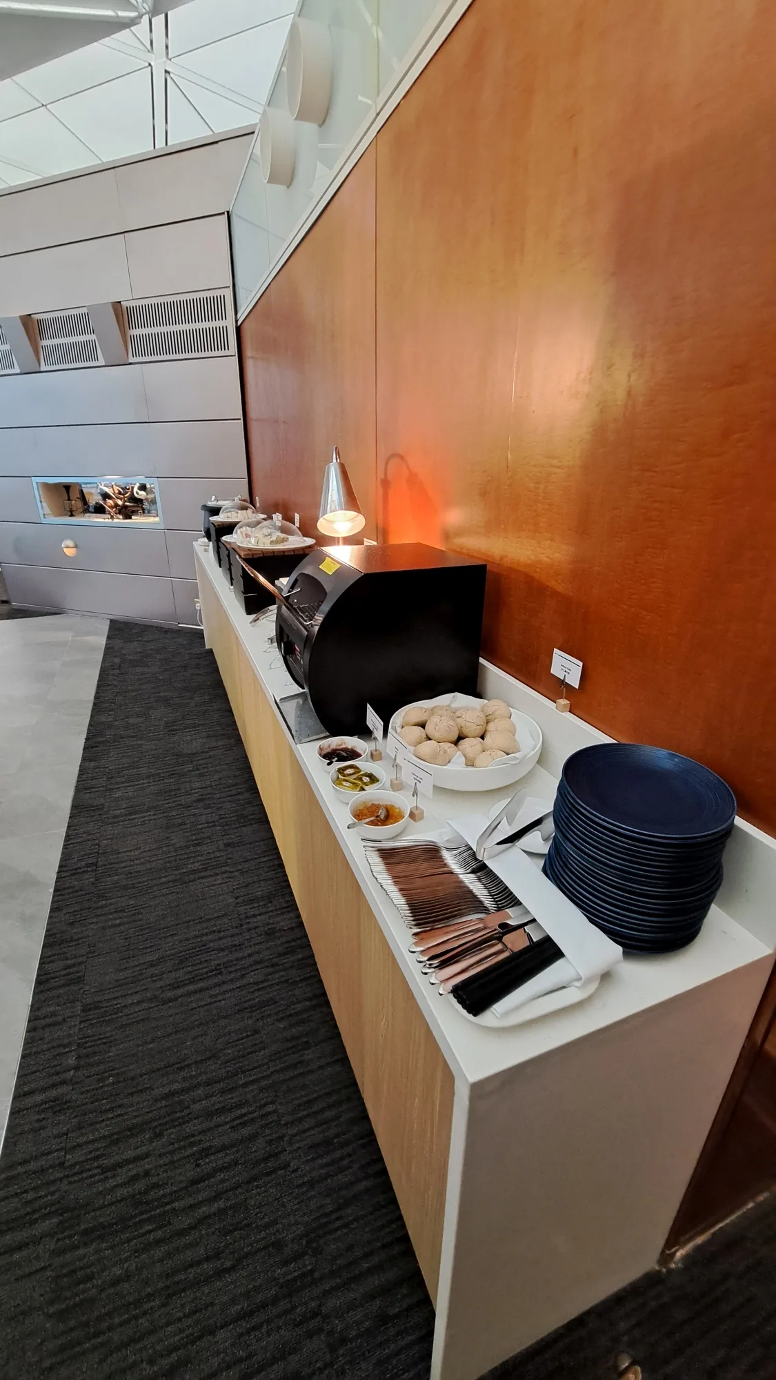 Buffet mit Tellern, Servietten und Gebäck im Flughafenlounge