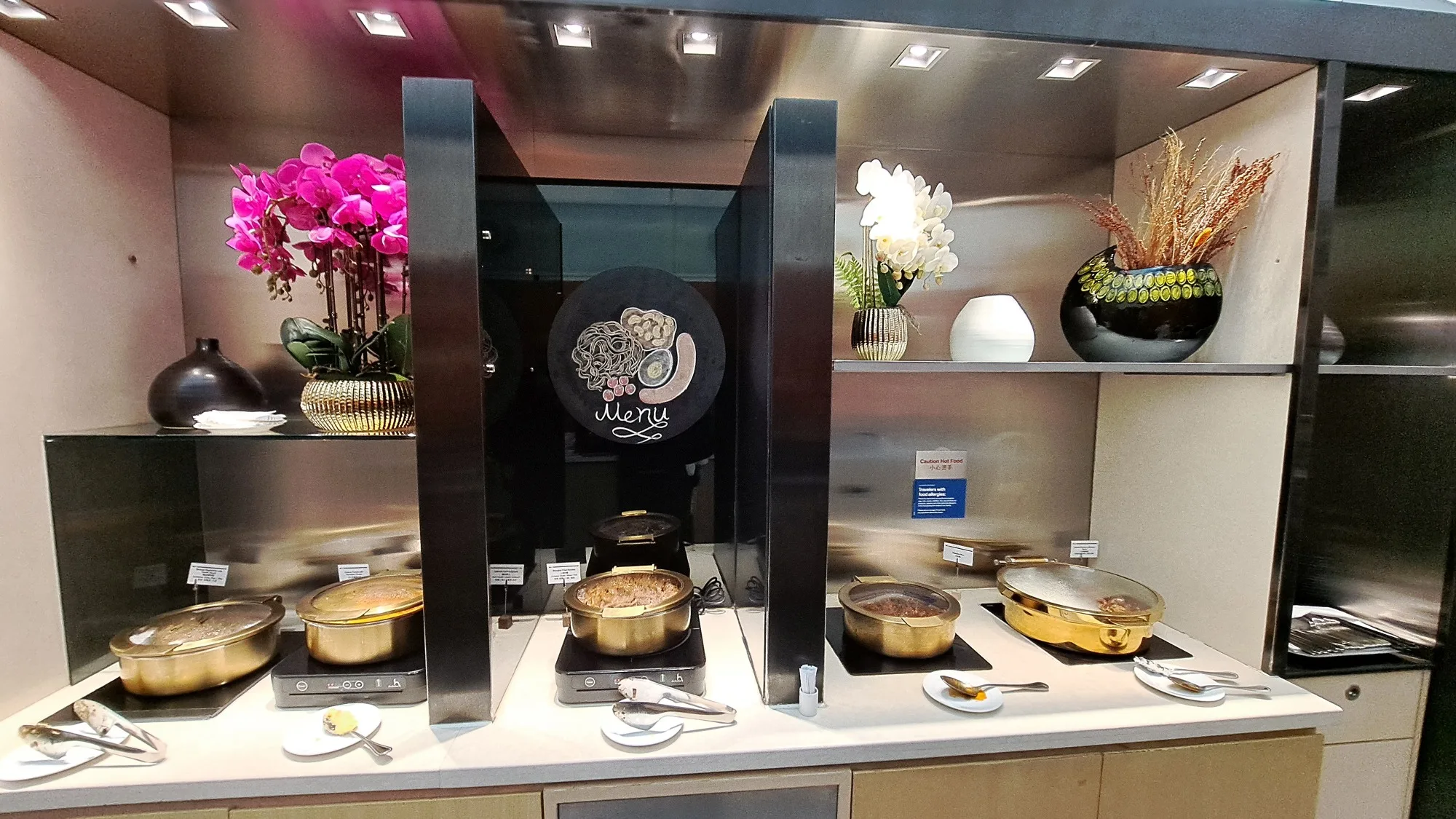 Buffet mit Kochstationen und dekorativen Blumenarrangements