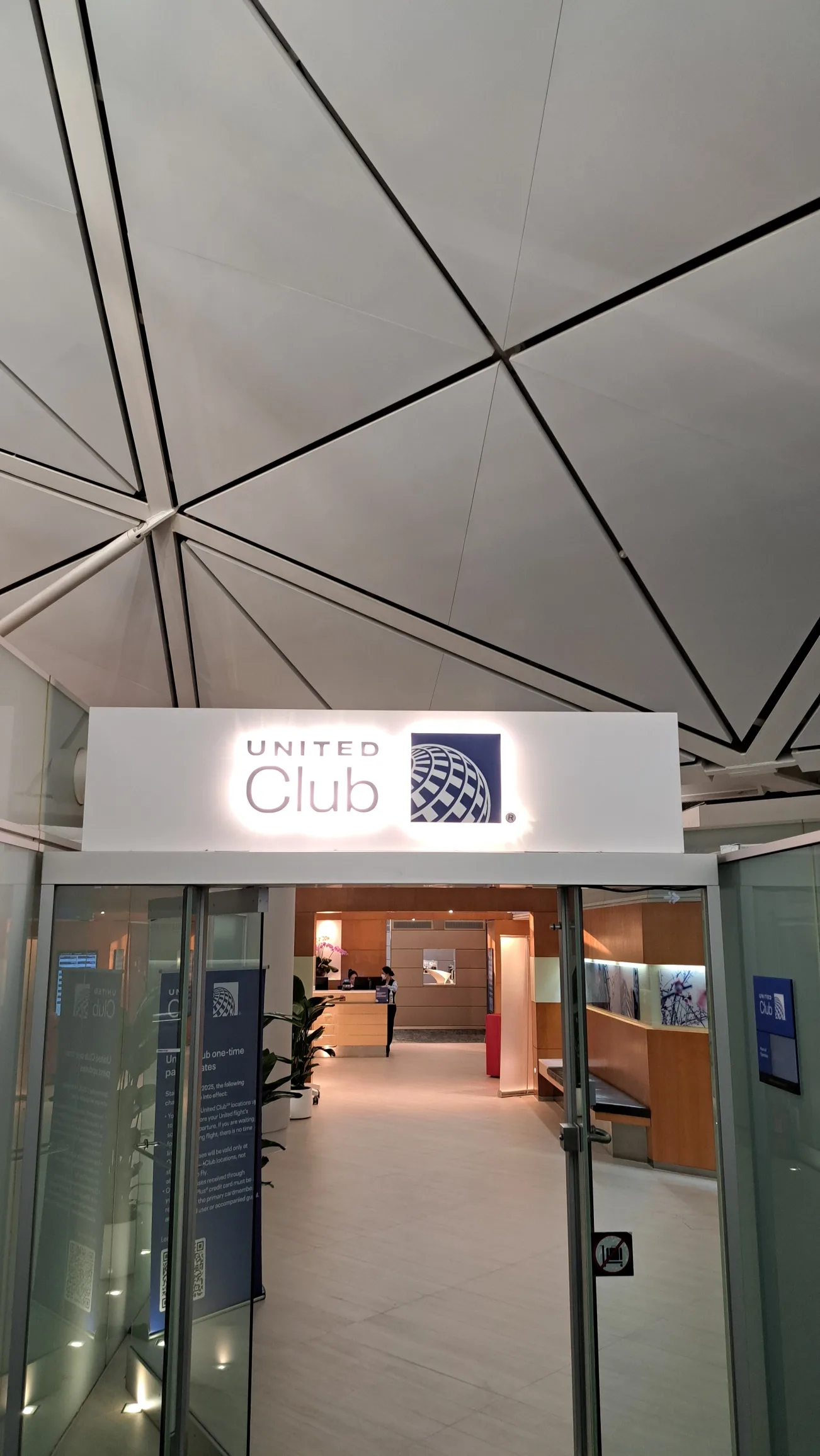 Eingang zum United Club mit Schild und moderner Deckenstruktur