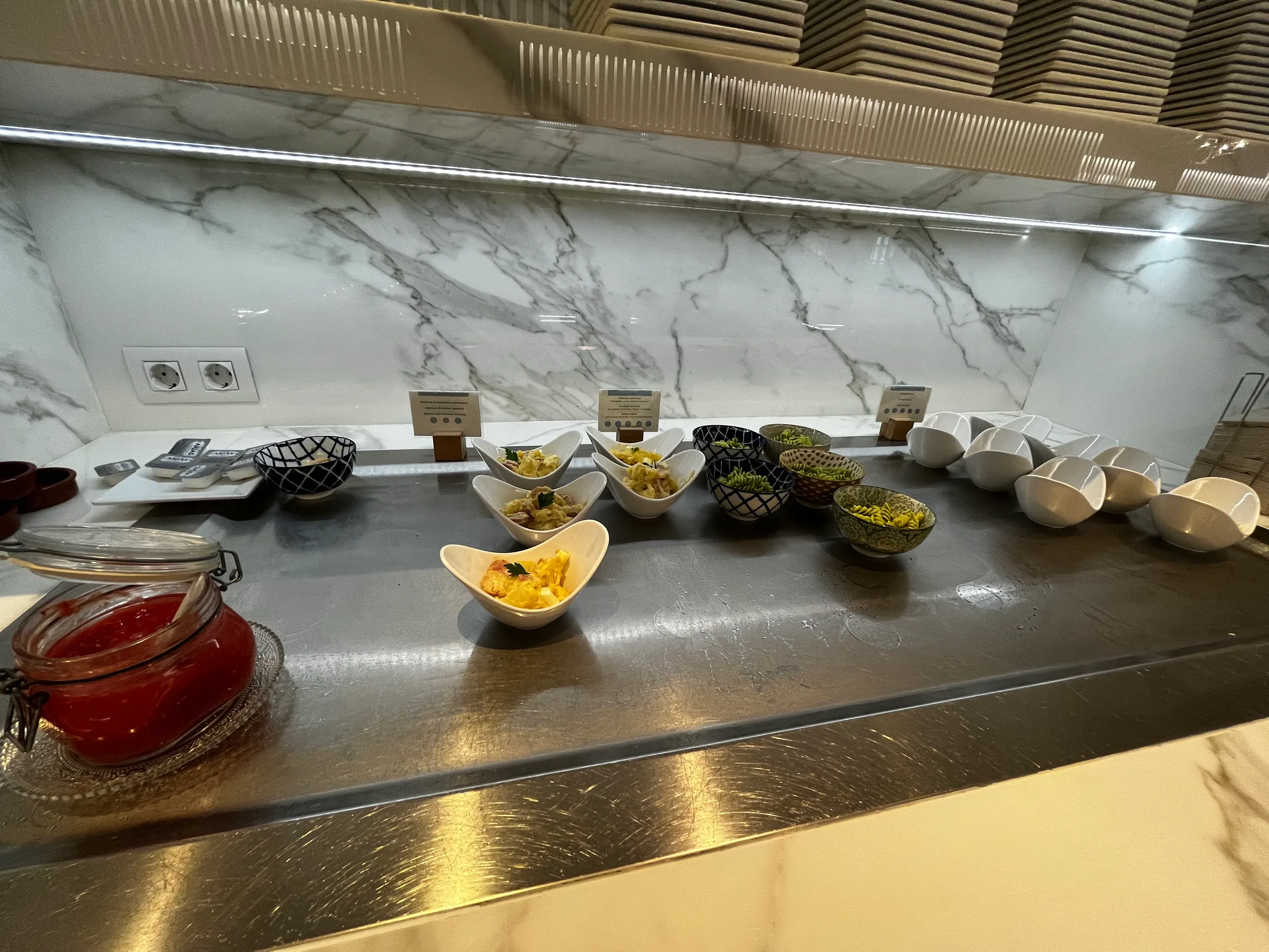 Buffet mit verschiedenen Salaten und Beilagen auf einer Metallplatte