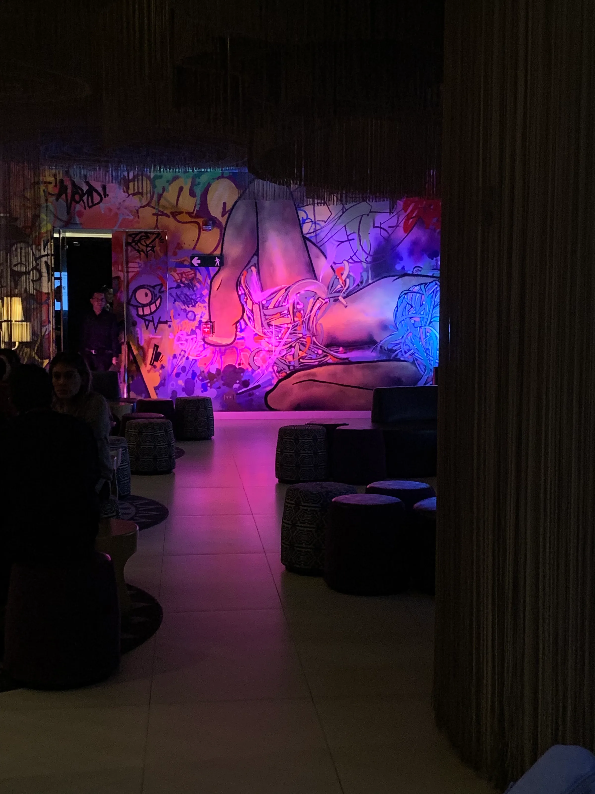Graffiti-dekorierte Lobby mit Sitzgelegenheiten und buntem Licht