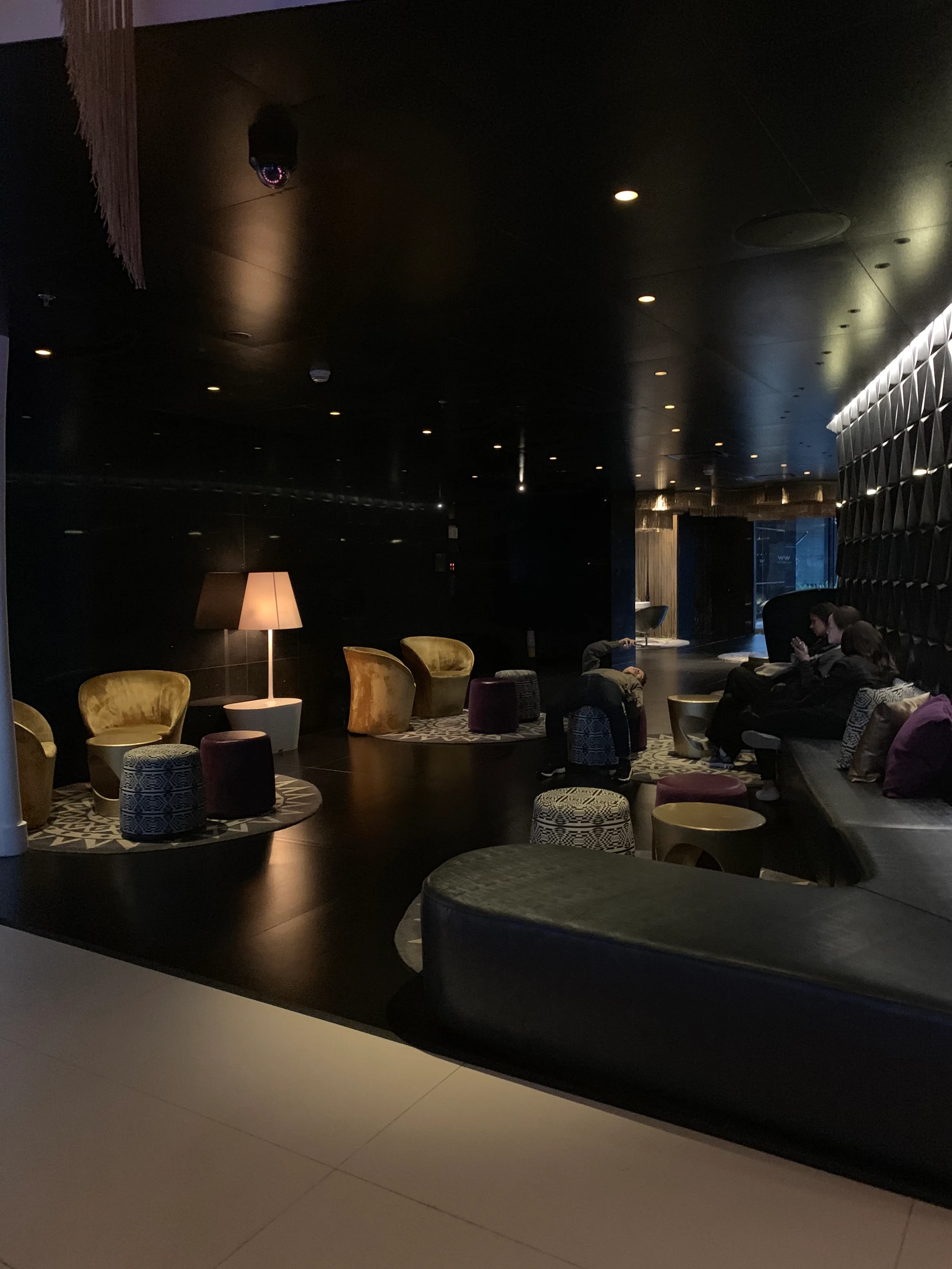 Loungebereich mit Sesseln und Poufs in gedämpftem Licht