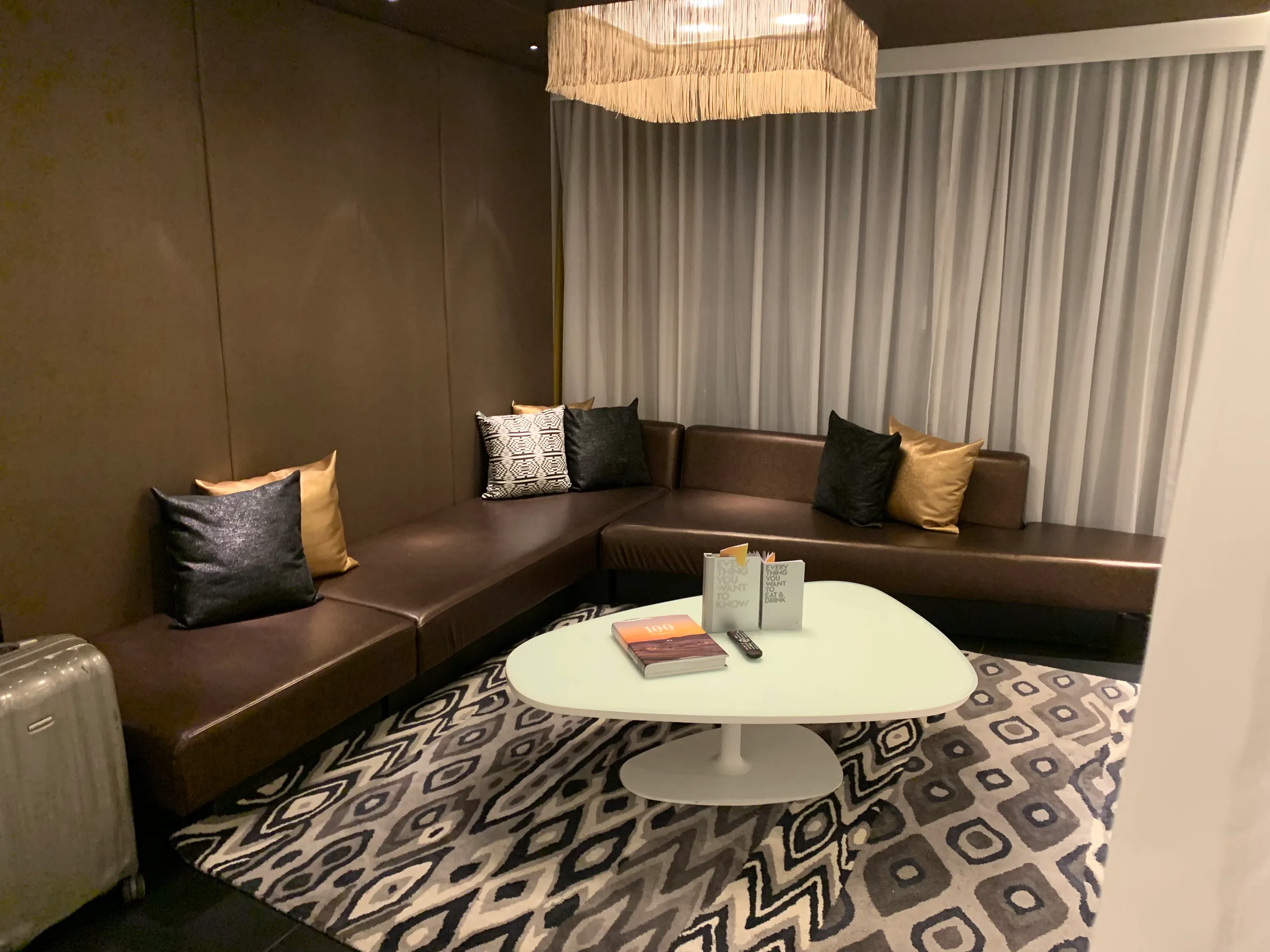 Lounge mit Ledersofa und Kissen in Grautönen