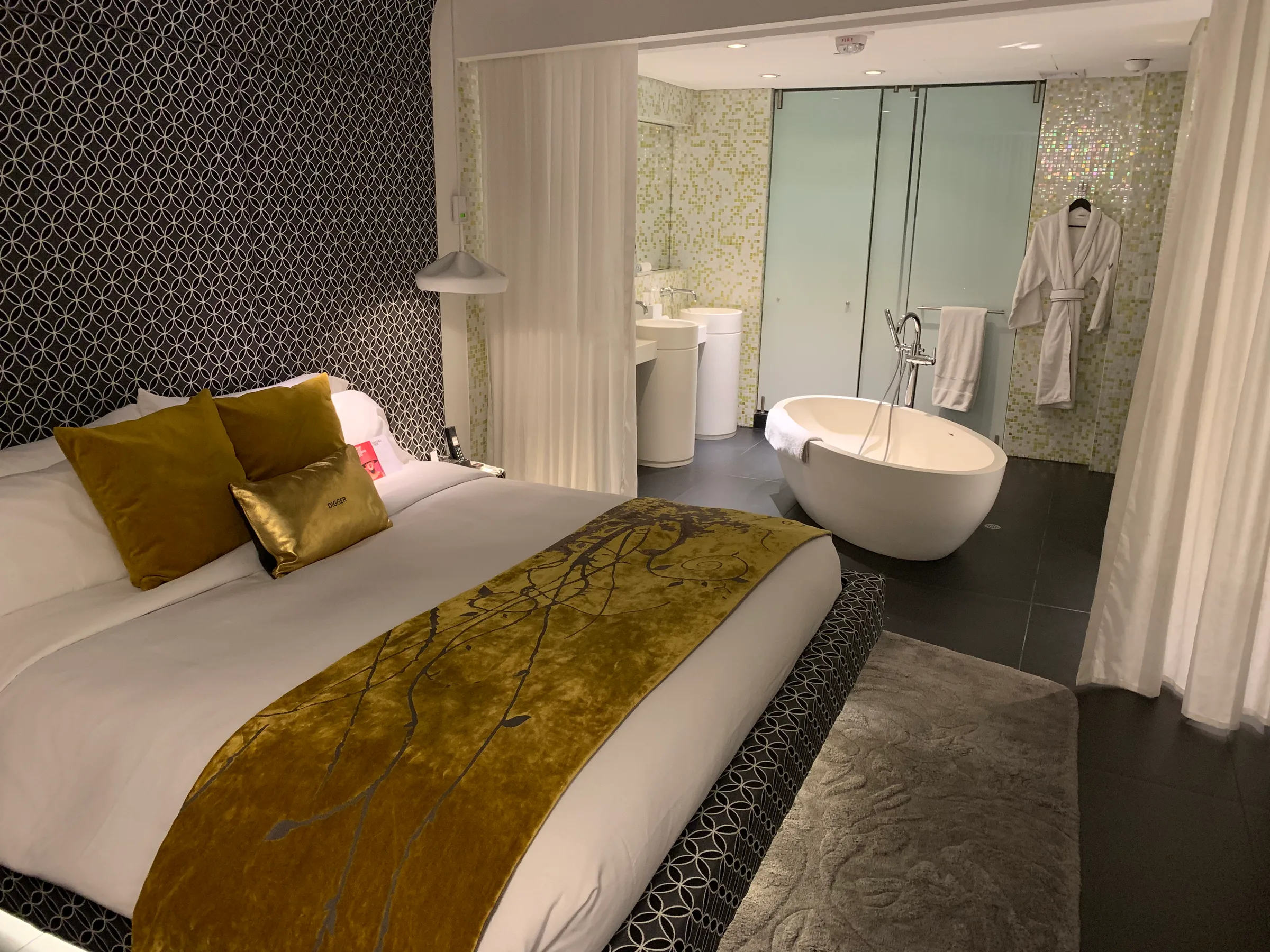 Doppelbett im Hotelzimmer mit goldenen Kissen und Tagesdecke