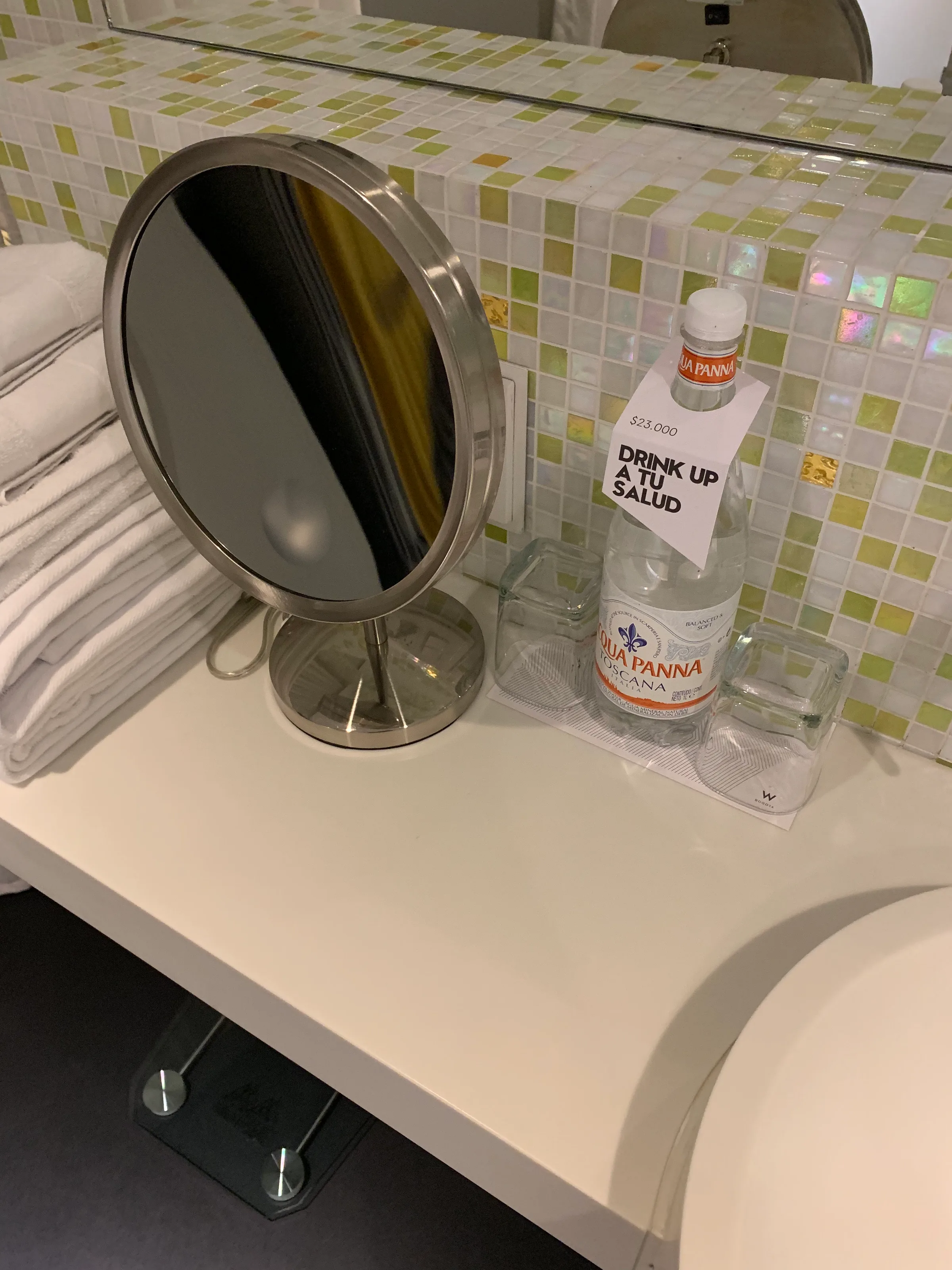 Hotelzimmerspiegel mit Wasserflasche und Notiz auf Tisch