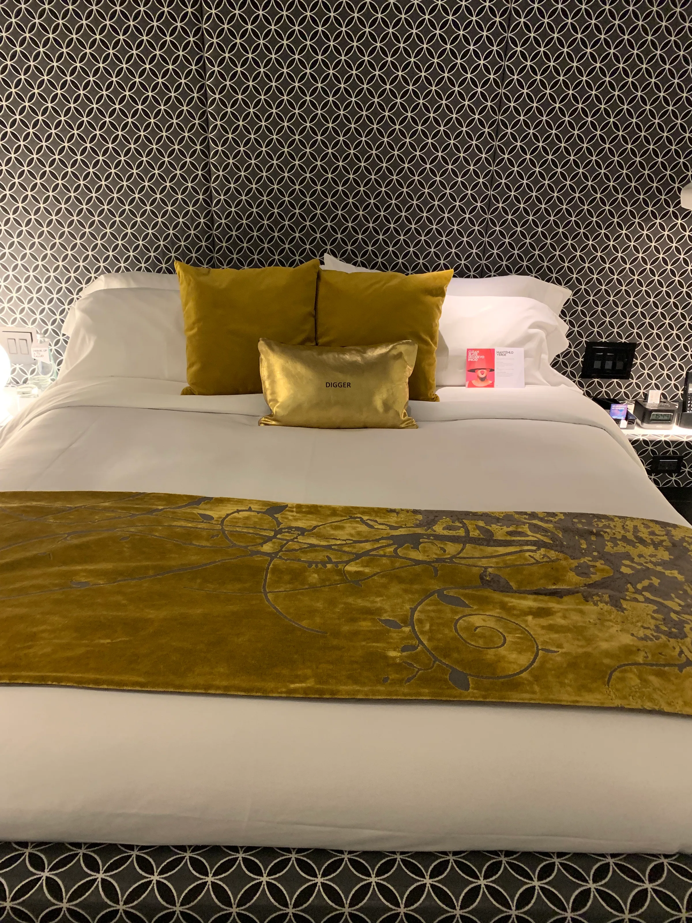 Doppelbett im Hotelzimmer mit gelben Kissen und Tagesdecke