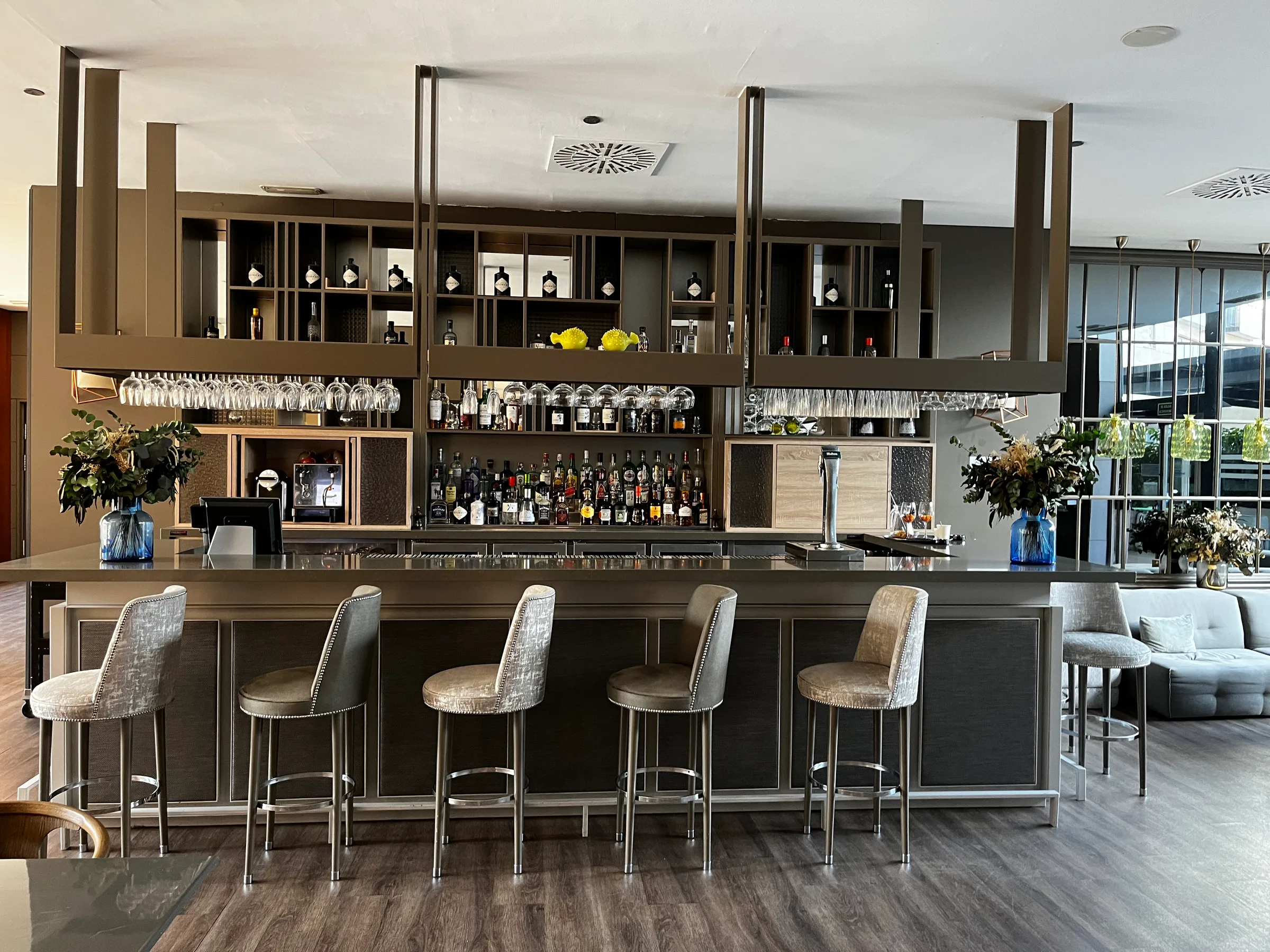 Bar mit Stühlen und Regalen voller Getränkeflaschen