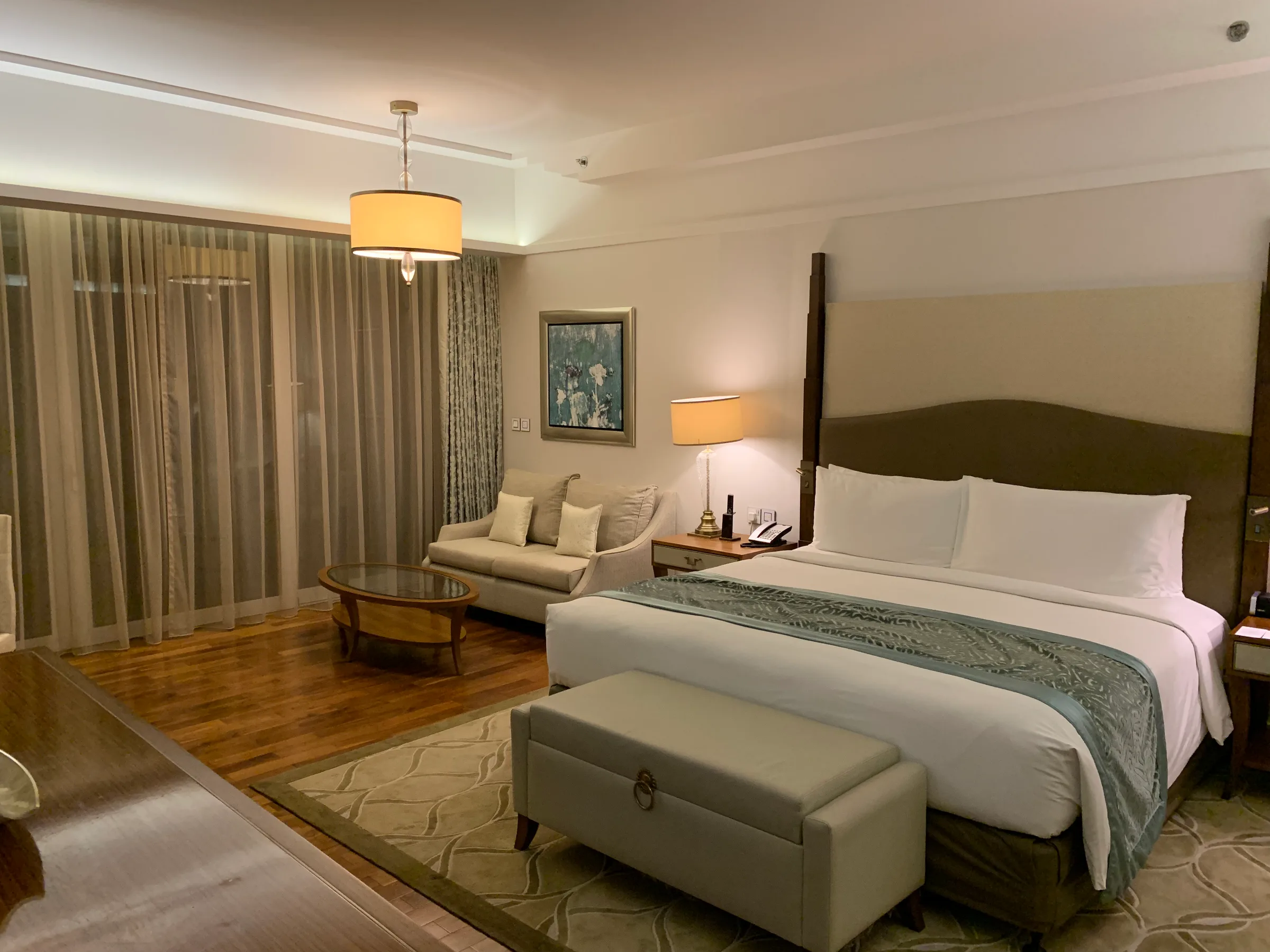 Hotelzimmer mit Doppelbett und Couch in neutralen Farben