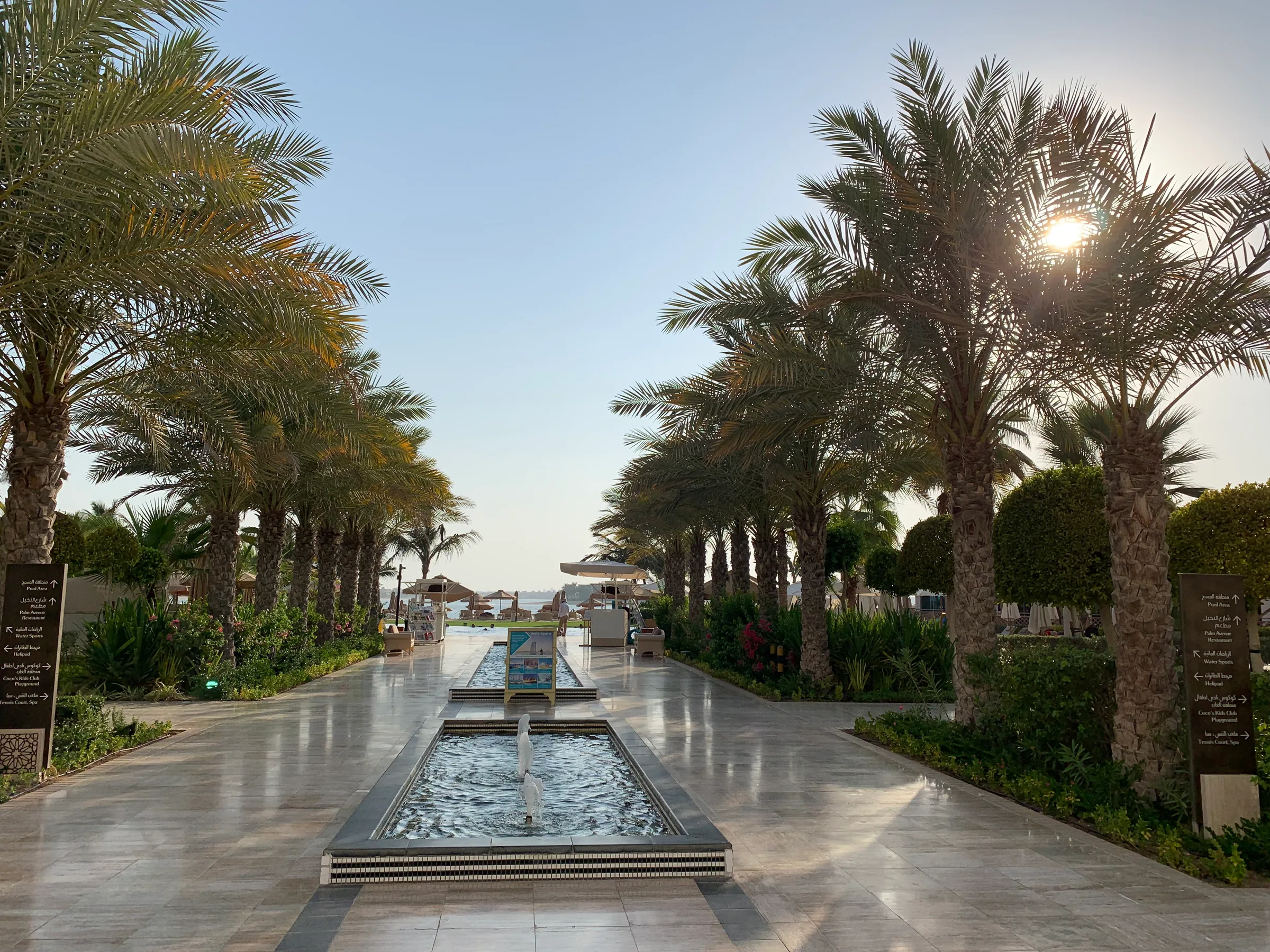 Palmengang mit Brunnen und Schildern am Waldorf Astoria Dubai Palm Jumeirah