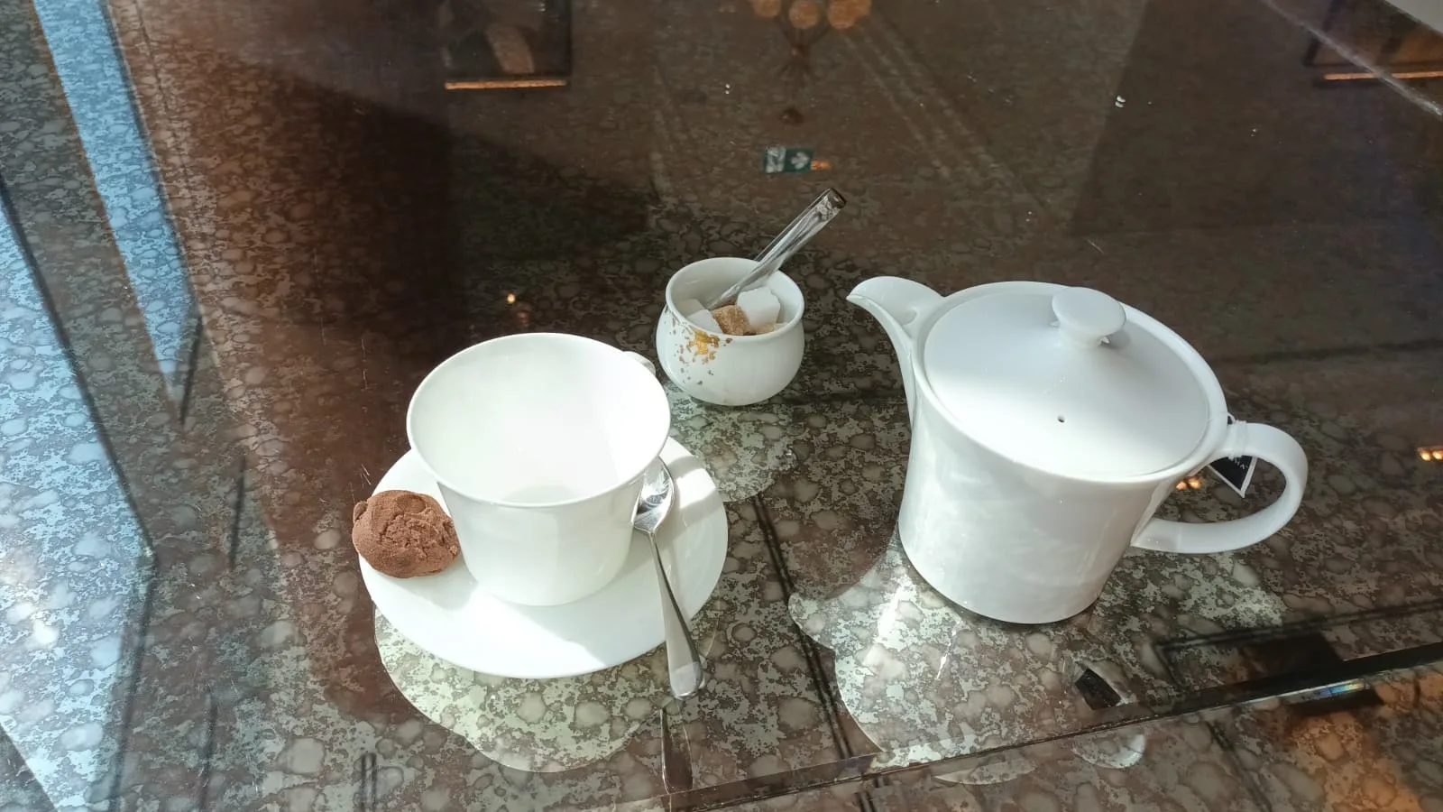 Teetasse und Kanne auf Marmortisch