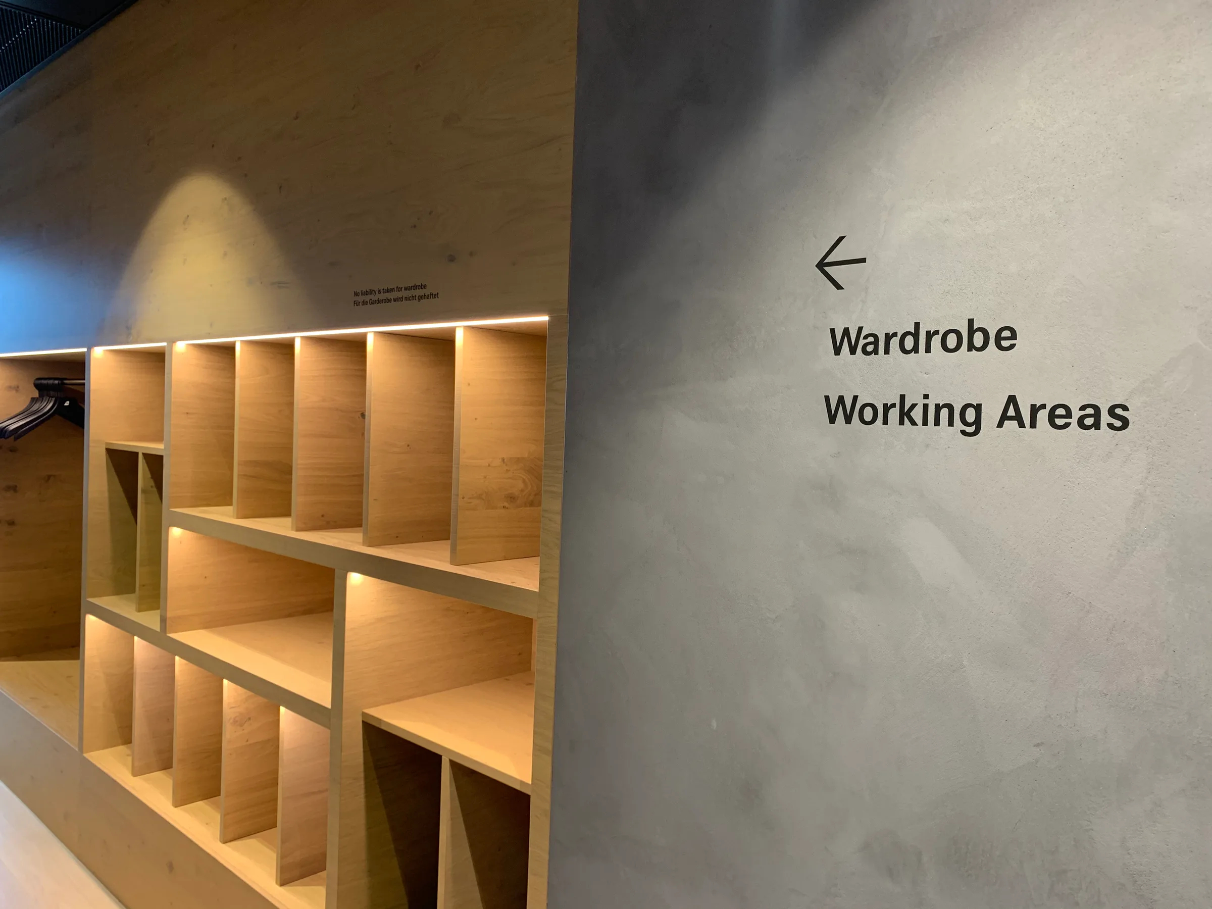 Holzregal mit Beleuchtung und Schilderung 'Wardrobe Working Areas'