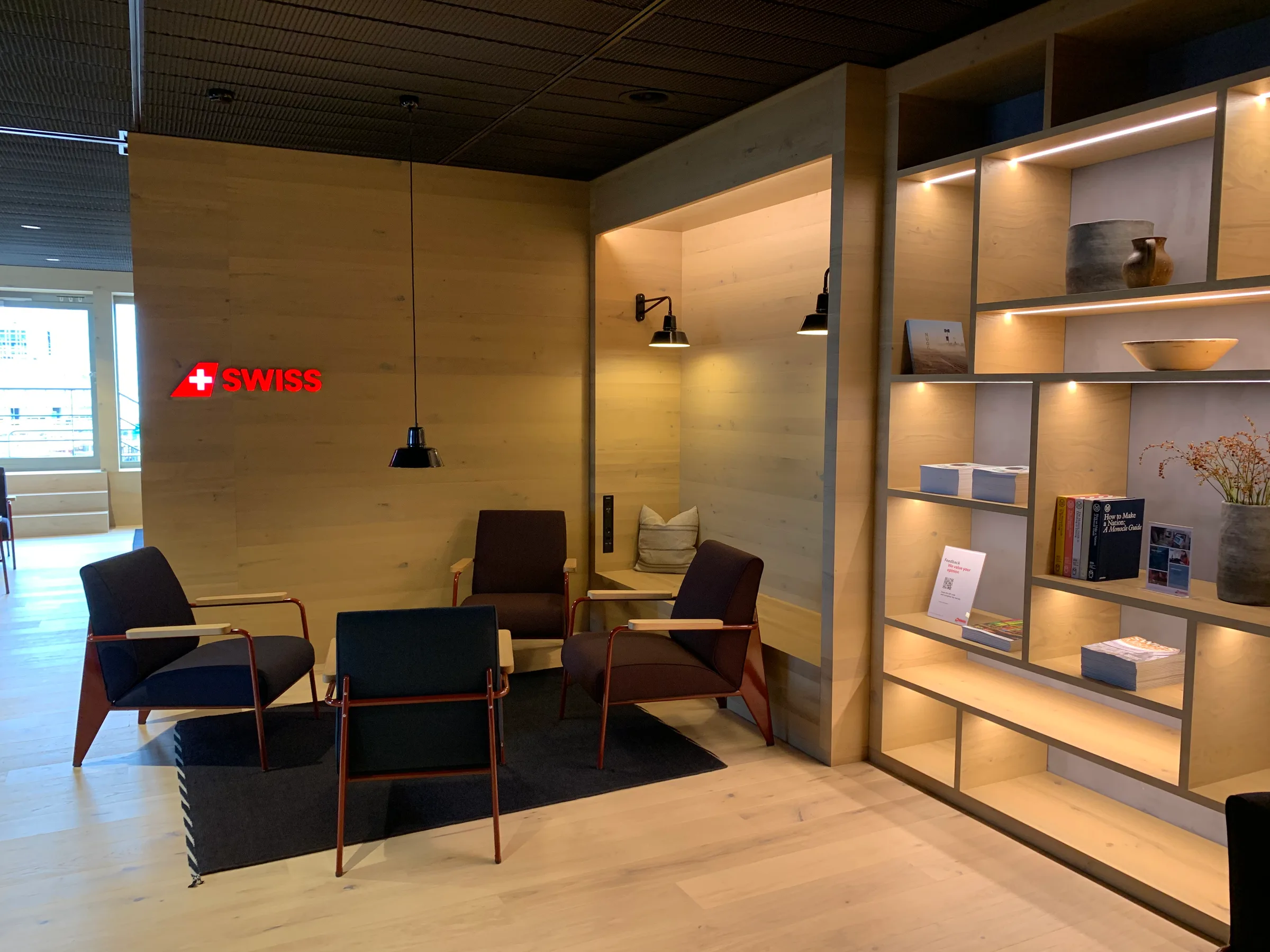 Lounge mit Holzwänden und Sesseln im Flughafen Zürich