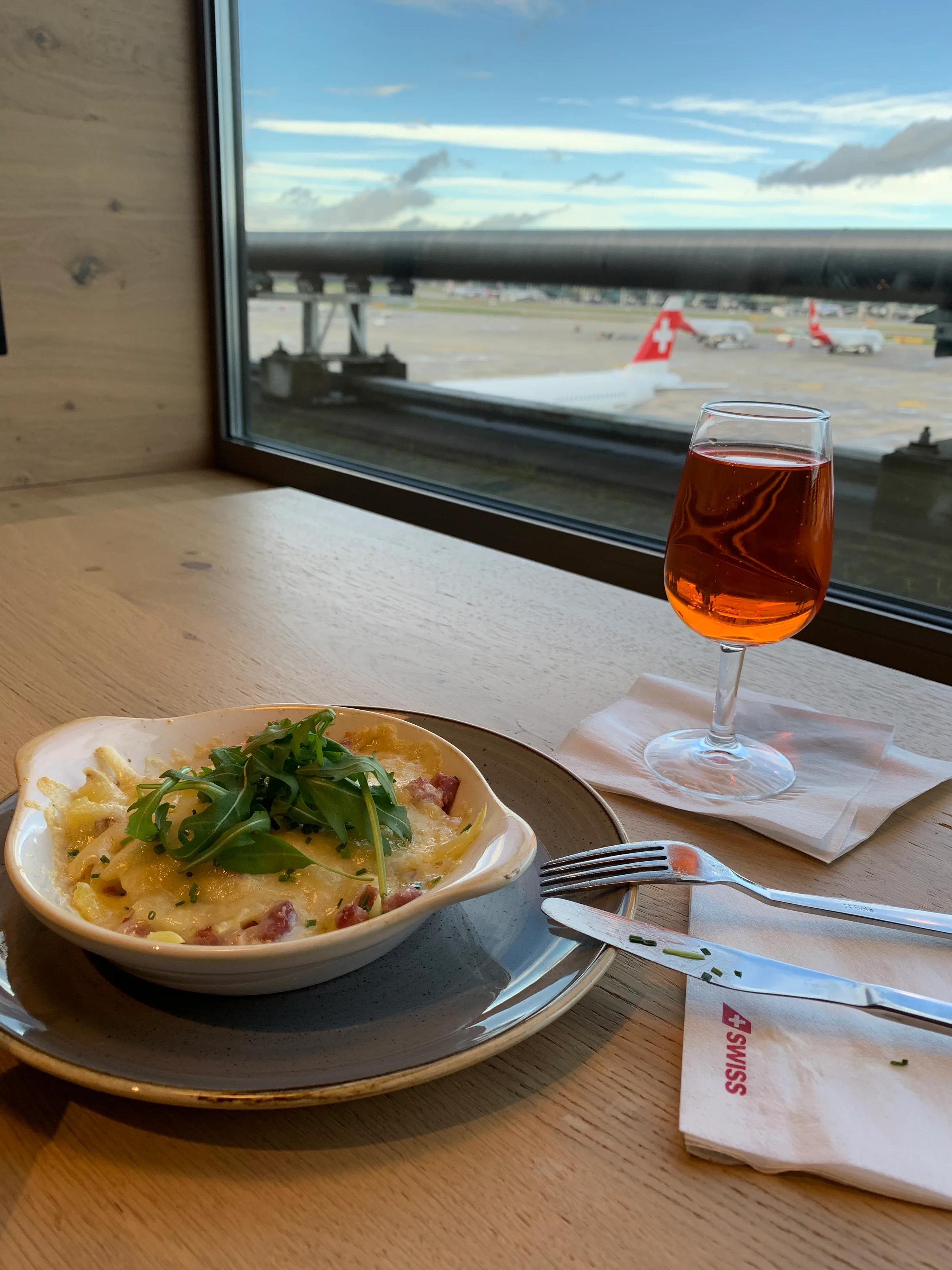 Gedeckter Tisch mit Essen und Getränk am Flughafenfenster